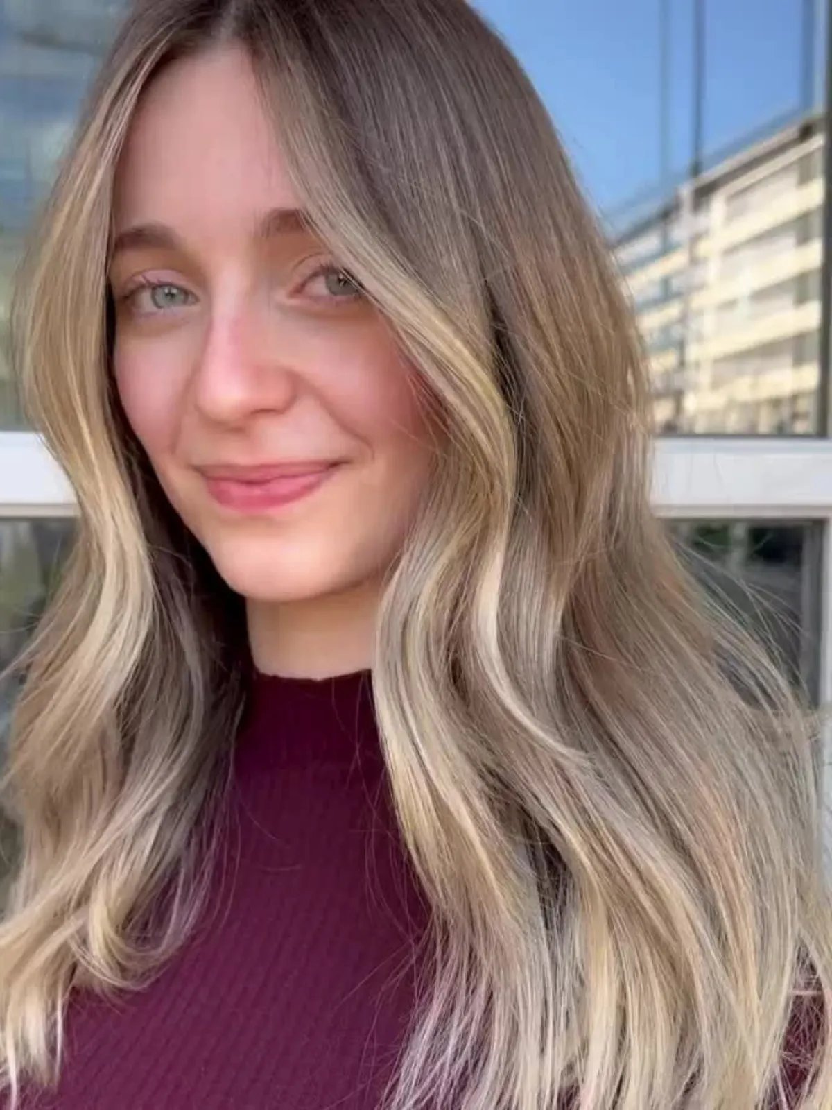 Model with long, loosely waved, neutral blonde hair featuring ashy, beige ribbons.