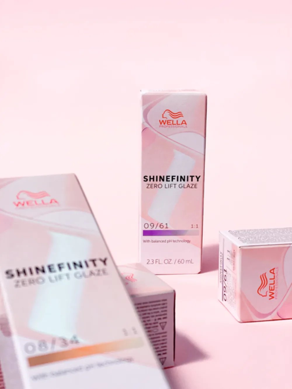 Wella Professionals Shinefinity product packaging displayed on a pink background.