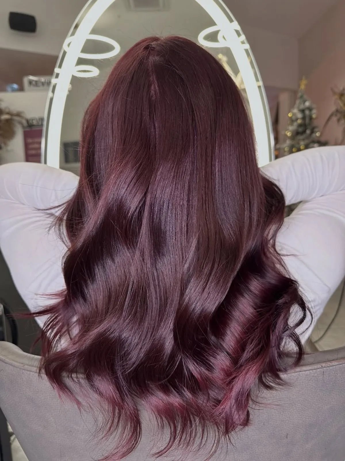 Model with long, loosely waved hair in a rich burgundy color.