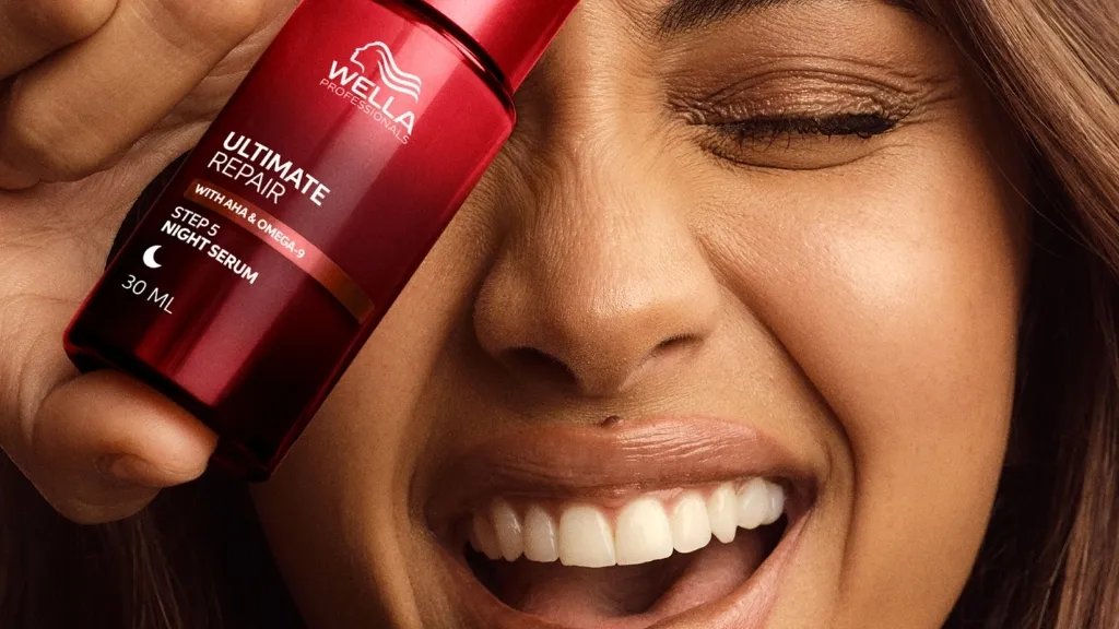 Model holds ULTIMATE REPAIR Night Serum in front of face.