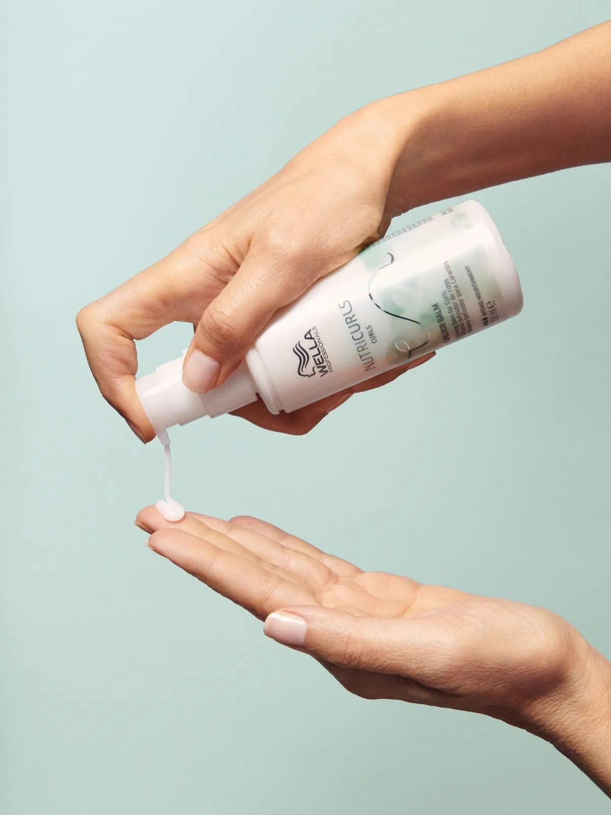 Model pumps NutriCurls Curlixir Balm into palm of hand. 
