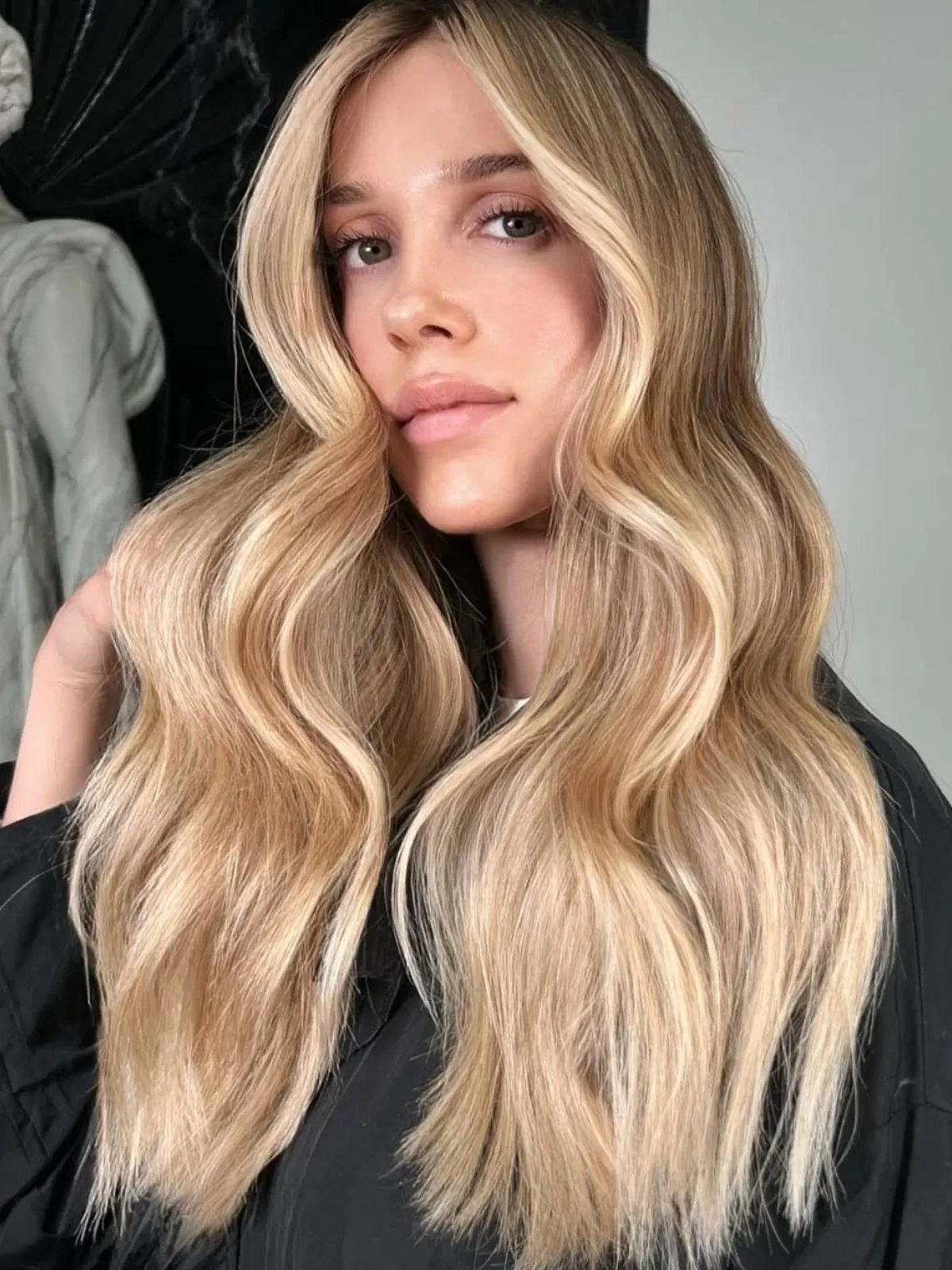 Model with long, wavy, butter blonde hair shown from a different angle.