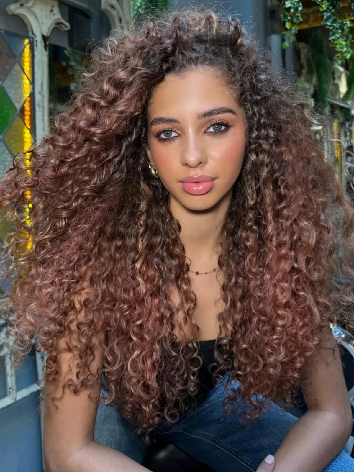 Model with long, curly, rose brown hair.
