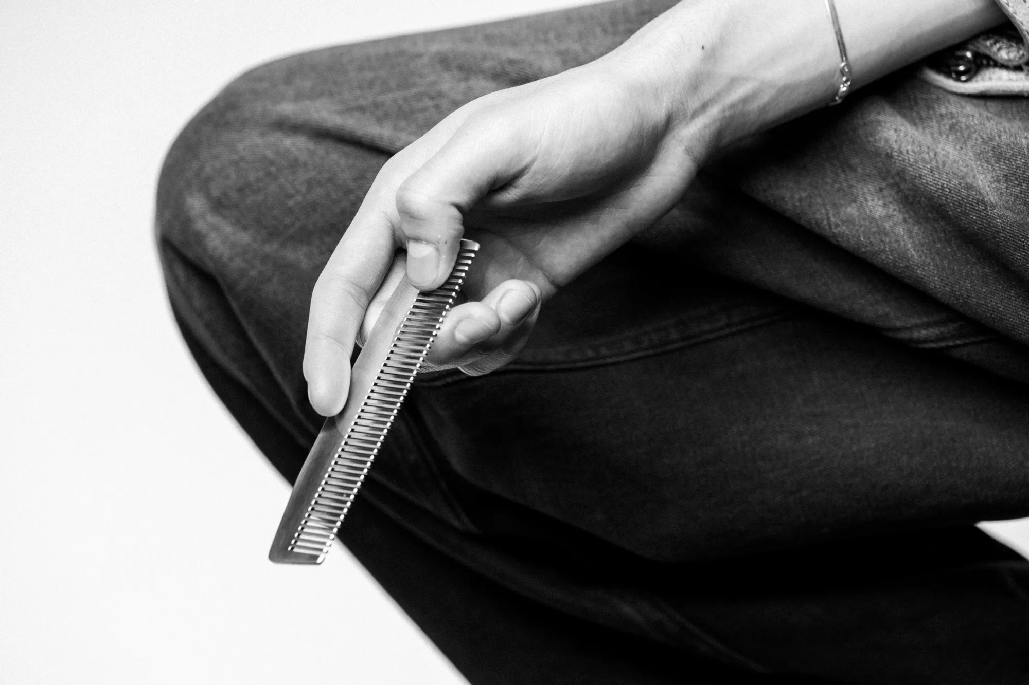 Primo piano in bianco e nero di un braccio che tiene un pettine