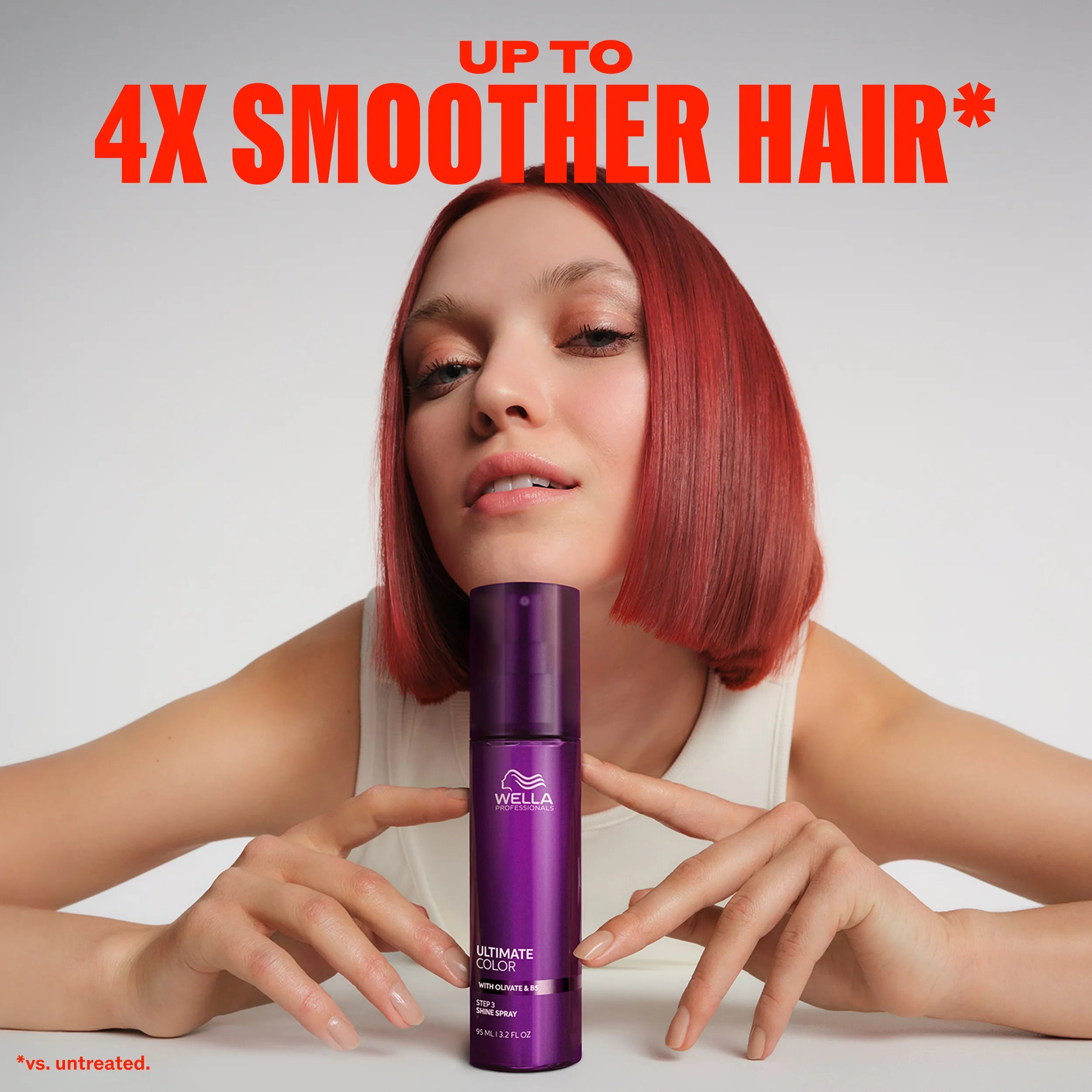 Model with short, red hair leaning their chin against a bottle of Ultimate Color shine spray. Text overlay reads "Up to 4x smoother hair* *vs.untreated".	