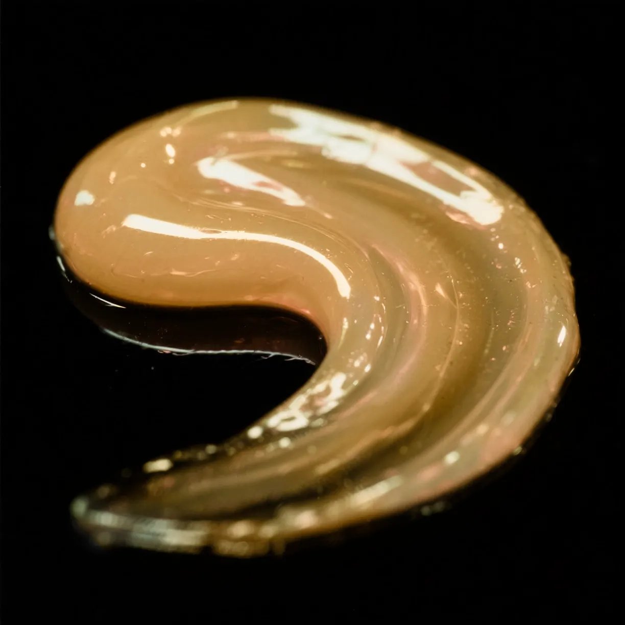 Primo piano di uno swatch di Cellophane Semi-Permanent Colour Gloss color biondo miele