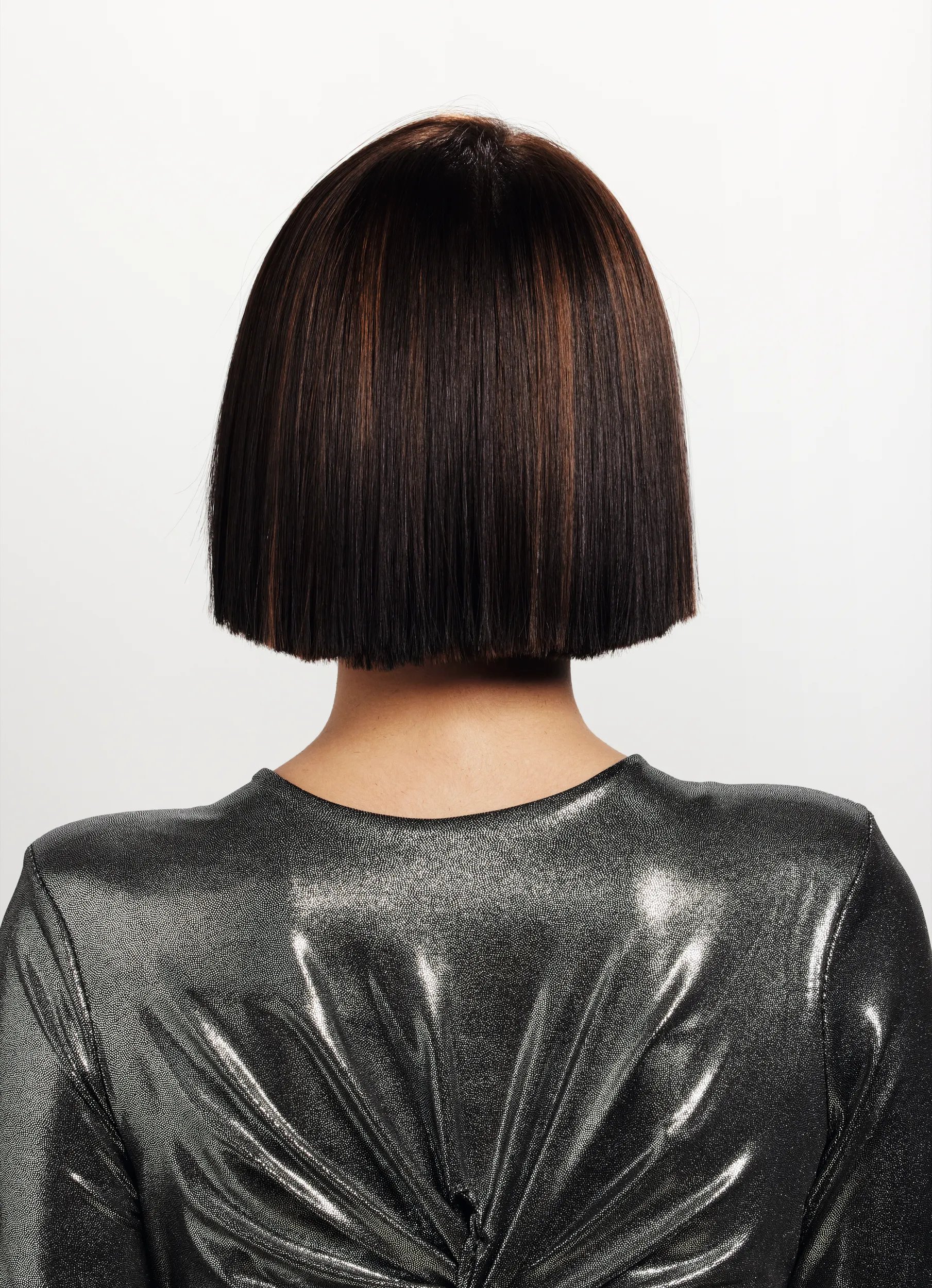 After image of a woman's hair from the hair with short black bob hair with added caramel highlights for dimension. 
