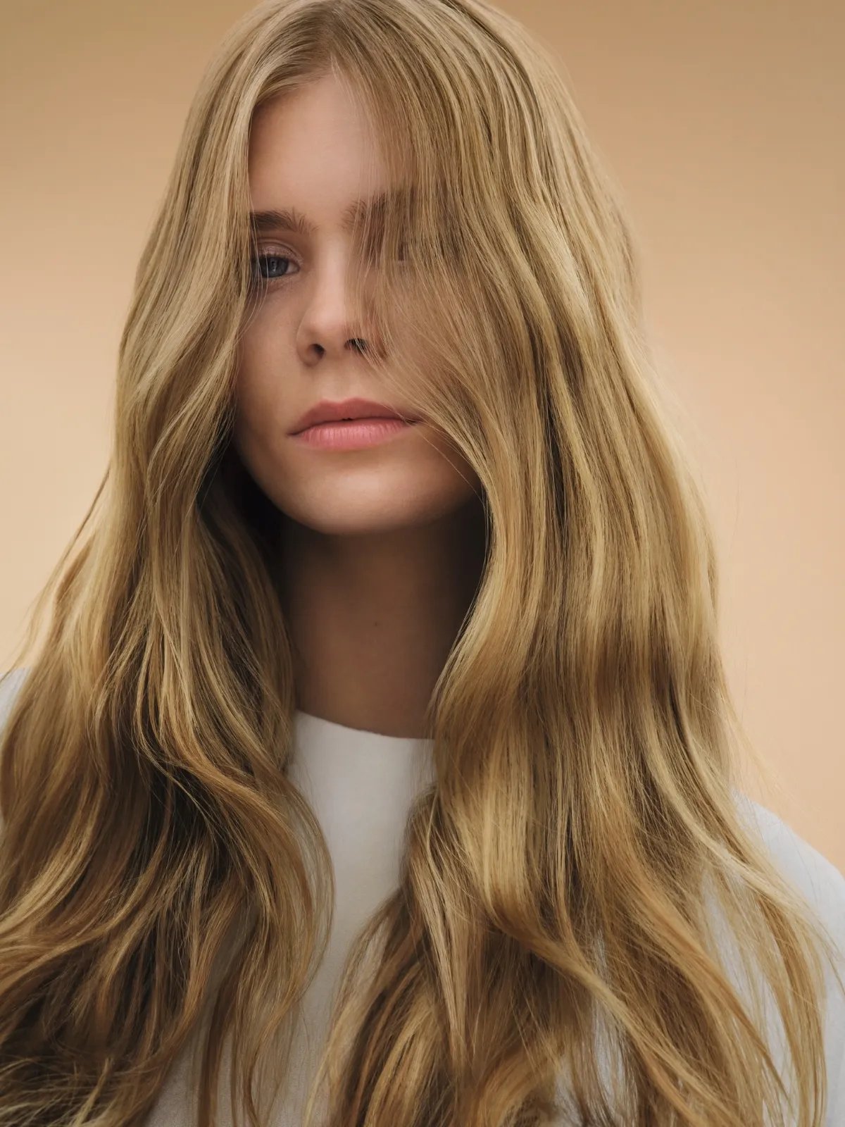 Model with long, smooth, wavy, honey blonde hair.