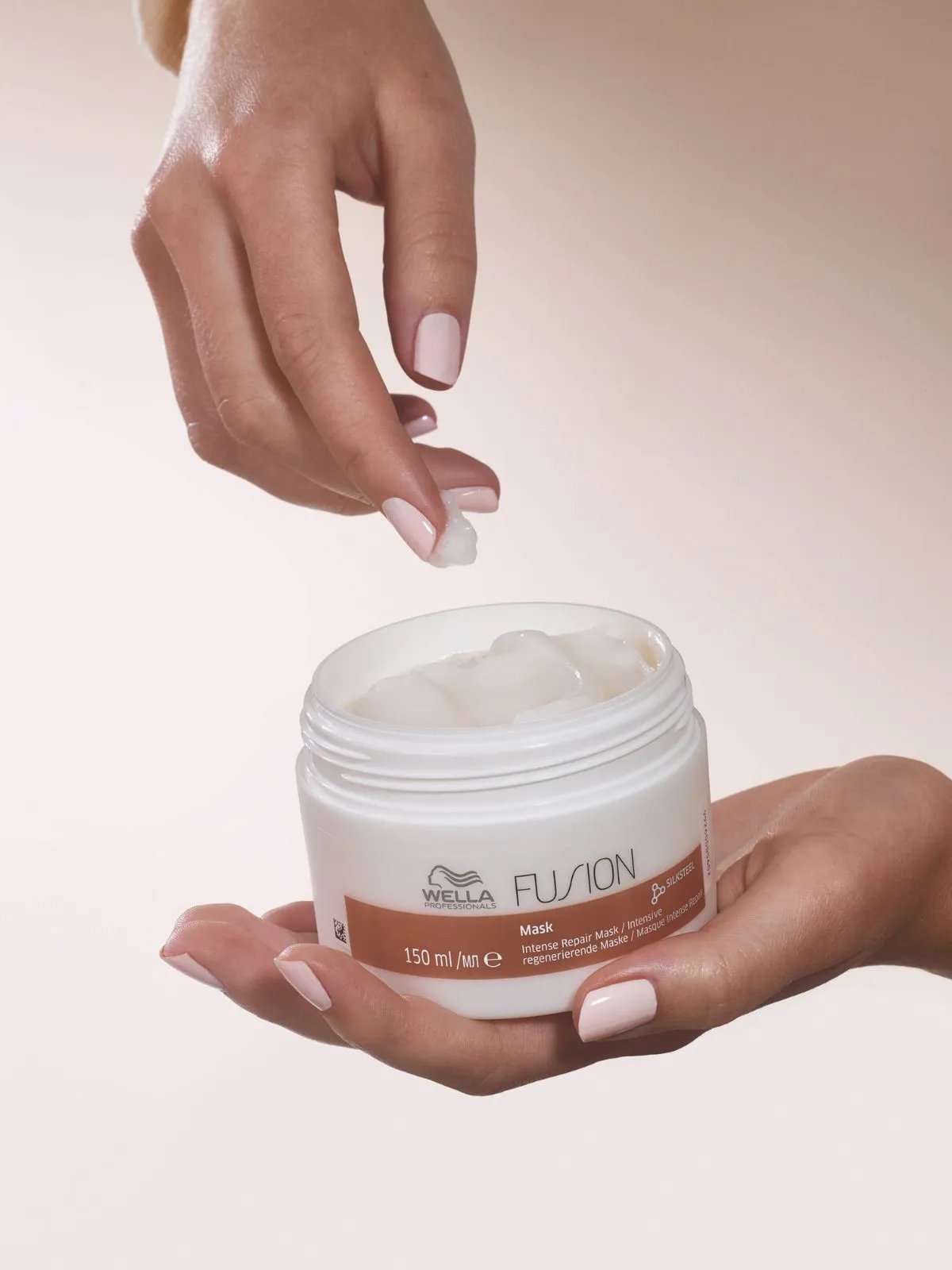 Model’s hand reaches into an open jar of Fusion Mask.
