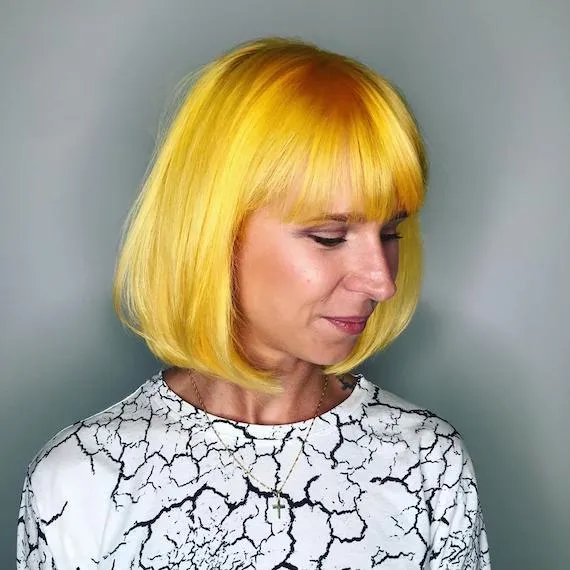 Woman with yellow bob haircut with a fringe, created using Wella Professionals