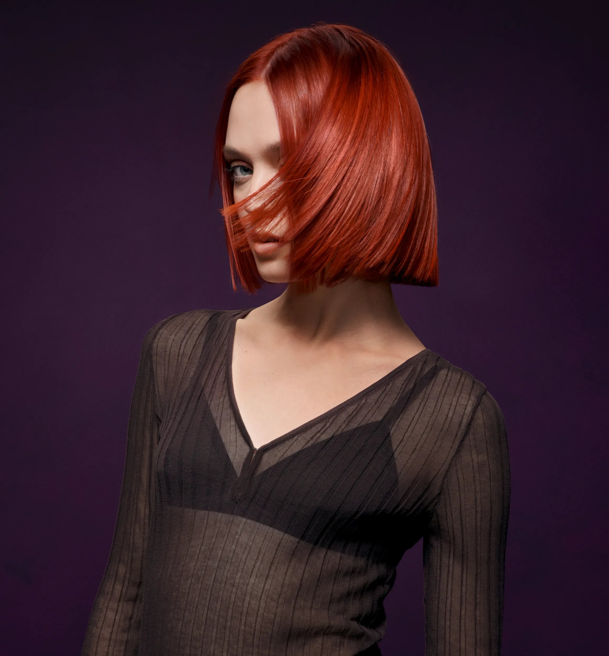 Frau mit glattem, kurzem und rotem Haar schaut in die Kamera