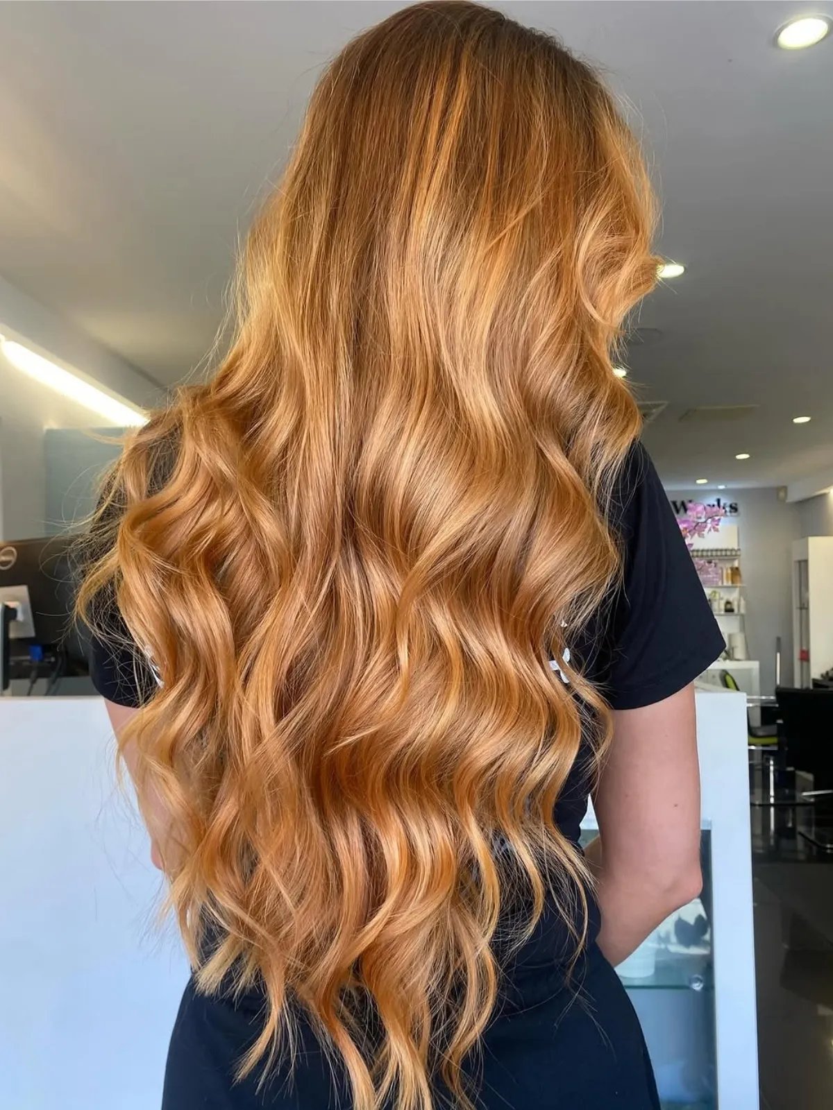 Model with ultra-long, wavy, strawberry blonde hair.