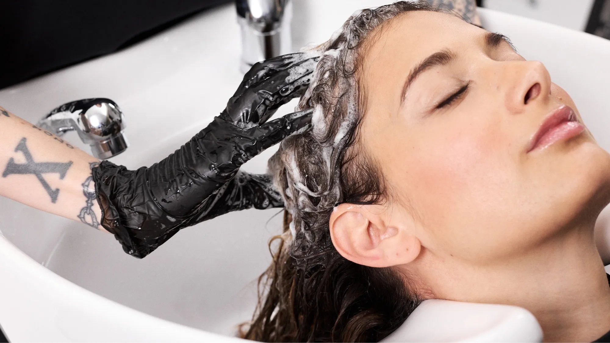 A model’s hair is washed at the sink.