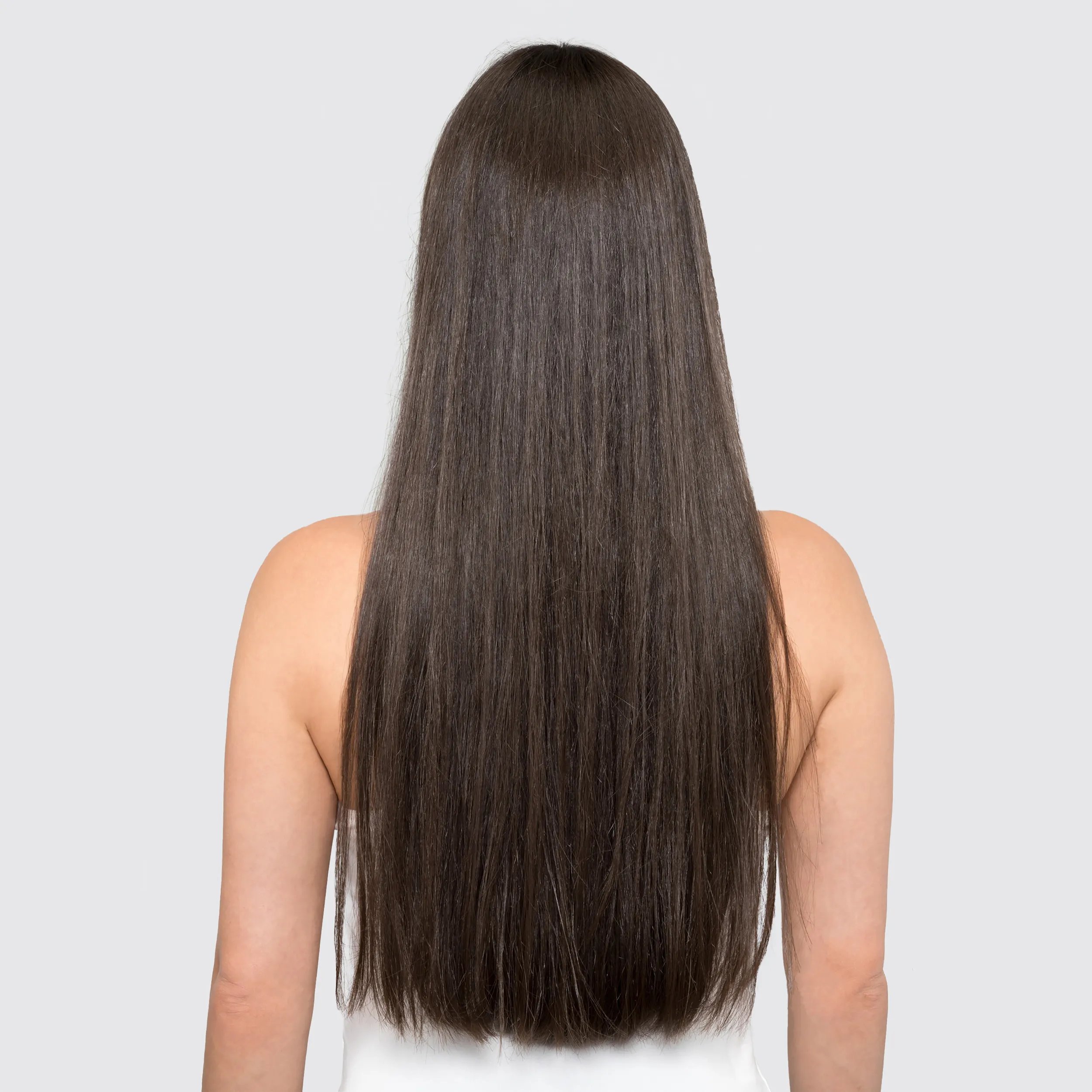 Model with long dark hair faces away from the camera. Hair looks dull and in need of care.