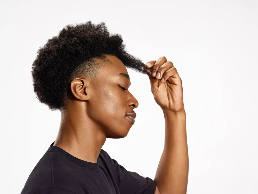 side profile of young black man stretching type 4  hair