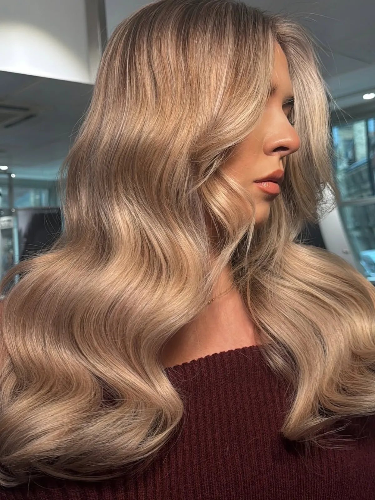 Model with long, loosely curled, dark champagne blonde hair