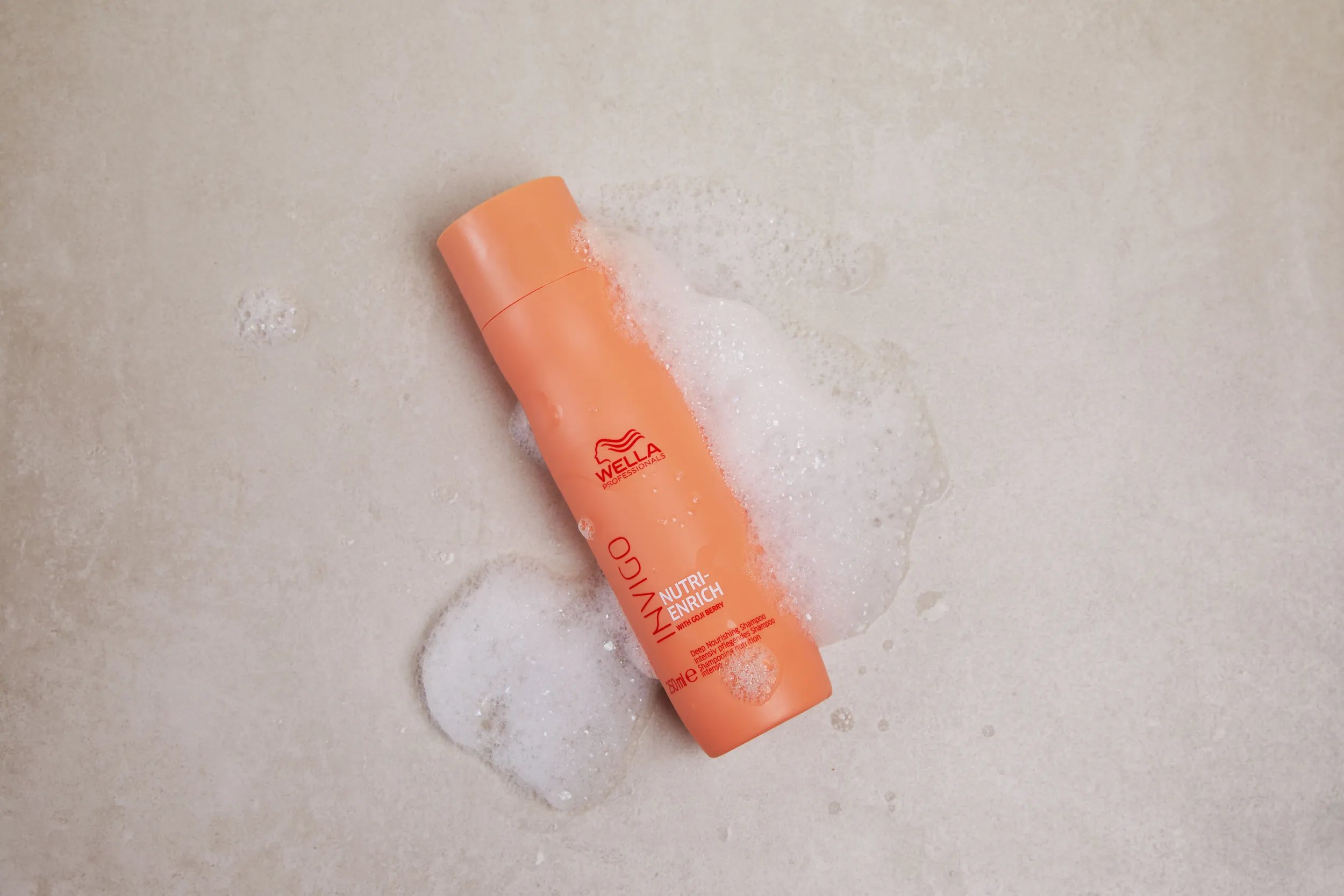 Bottle of Invigo Nutri Enrich Shampoo and foam