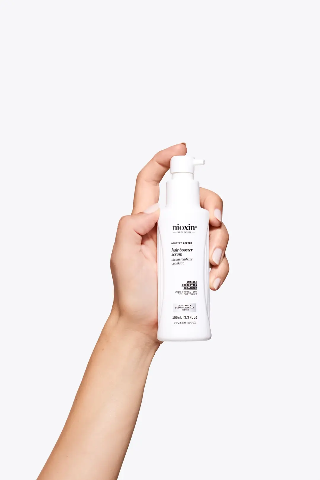 Nioxin Hair booster serum in hand against white background