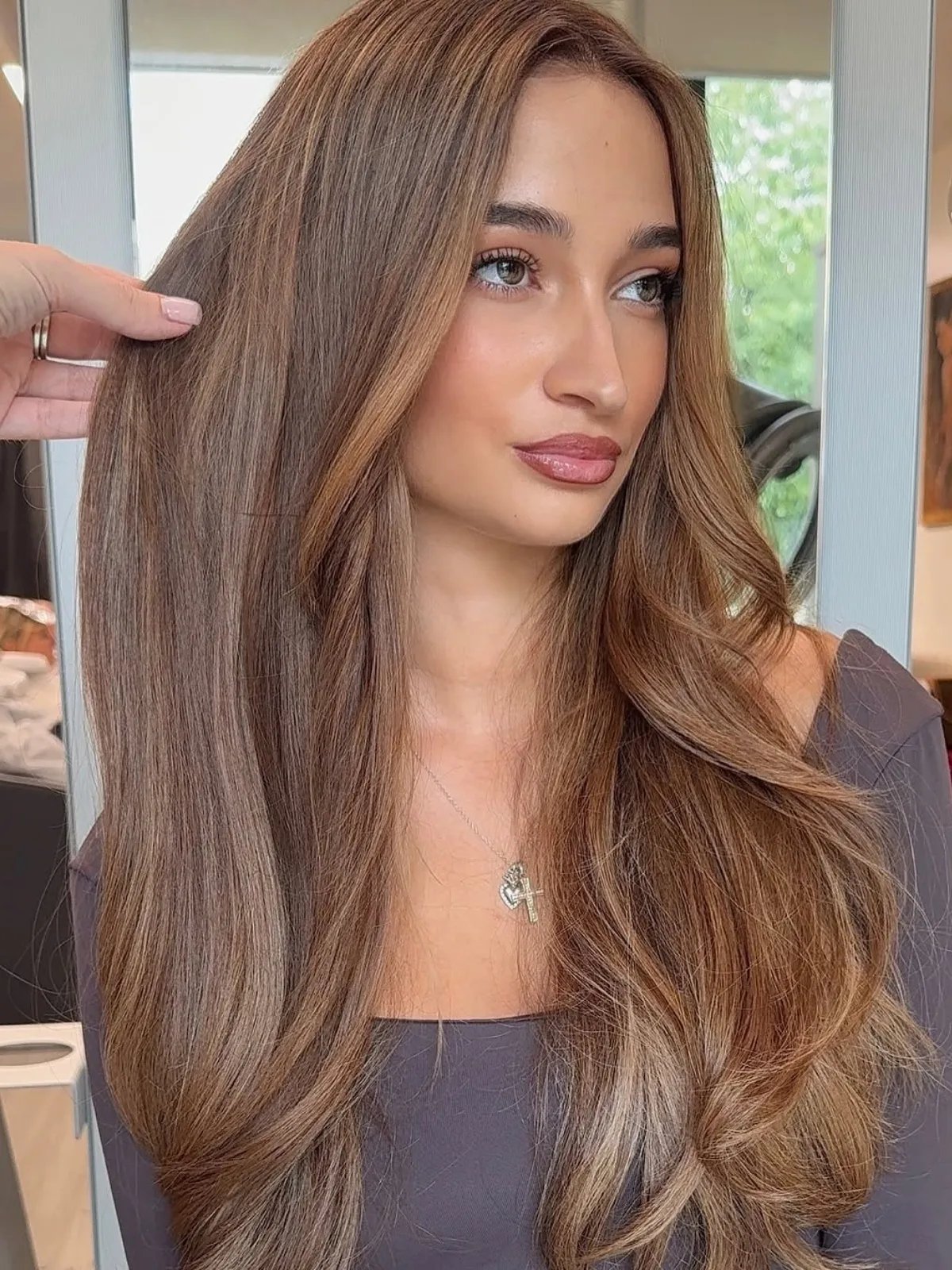Model with long, dark hair, featuring teddy bear brown highlights.