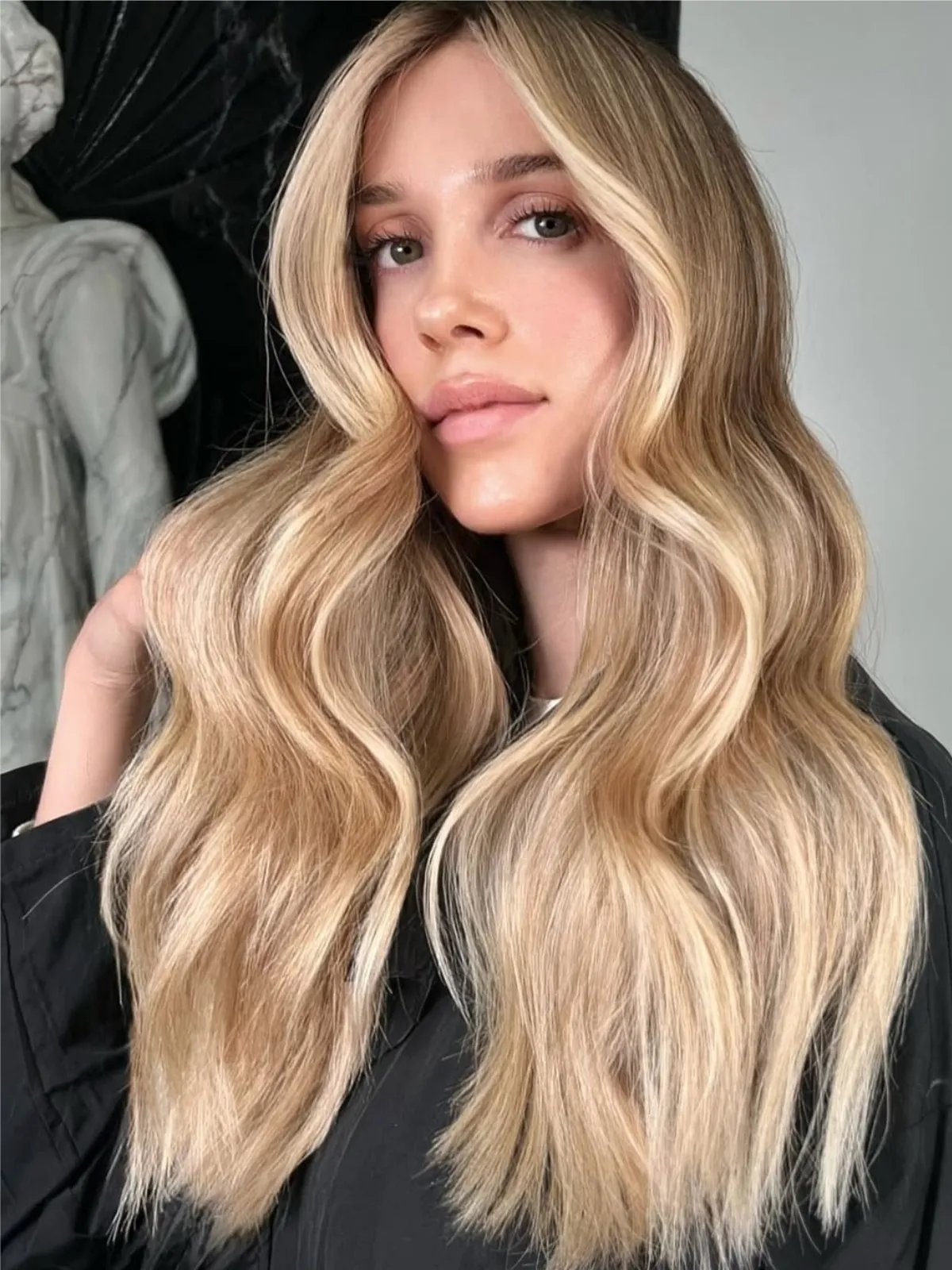 Model with long, honey blonde, wavy hair featuring a lighter face frame.