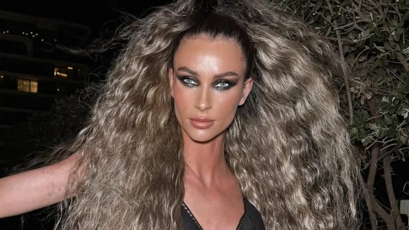 Model with ultra-long, bronde hair styled in crimped beach waves.