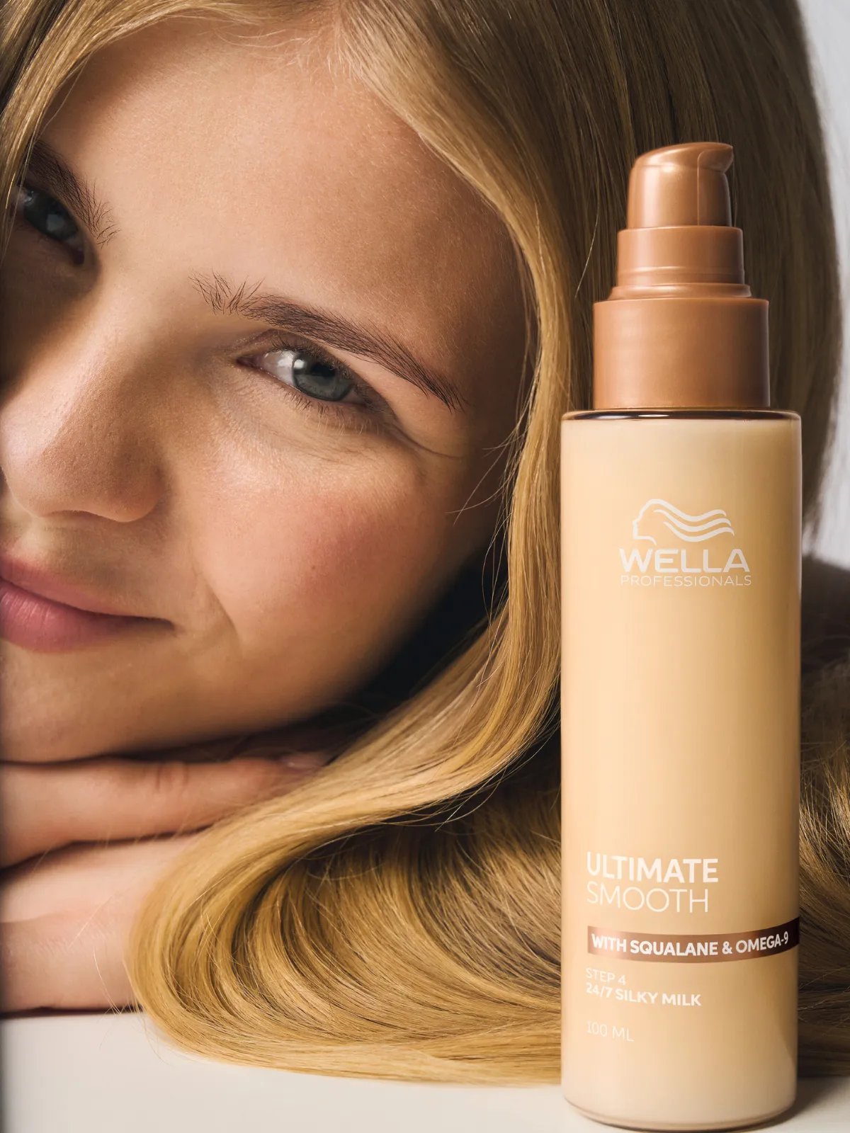 Blonde model poses with ULTIMATE SMOOTH Silky Milk.