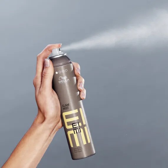 Hand holds EIMI Fresh Up spray.