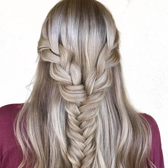 Back of woman’s head with blonde, half-up braid, created using Wella Professionals.