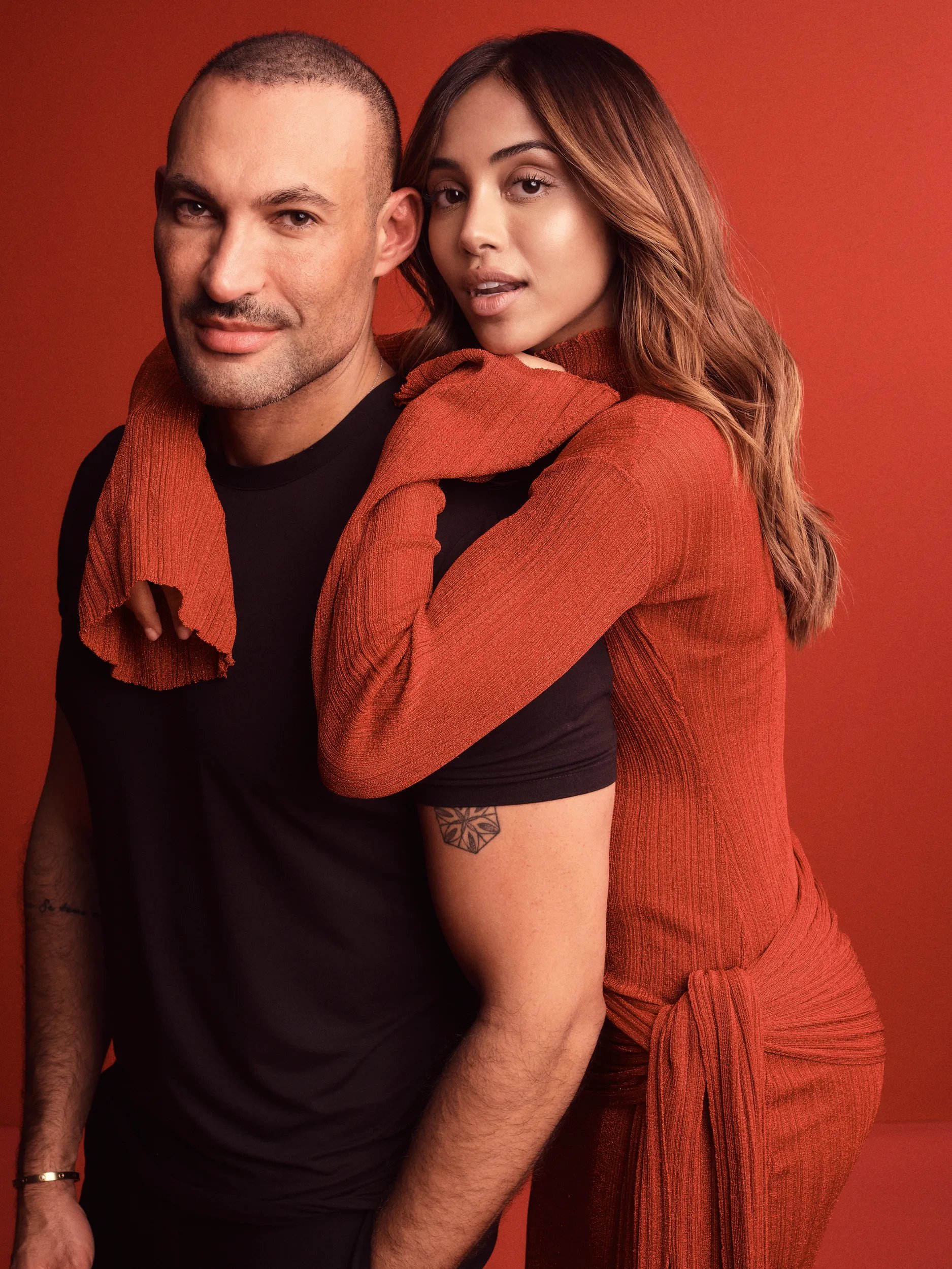 Portrait of Romeu Felipe and a model over a red background