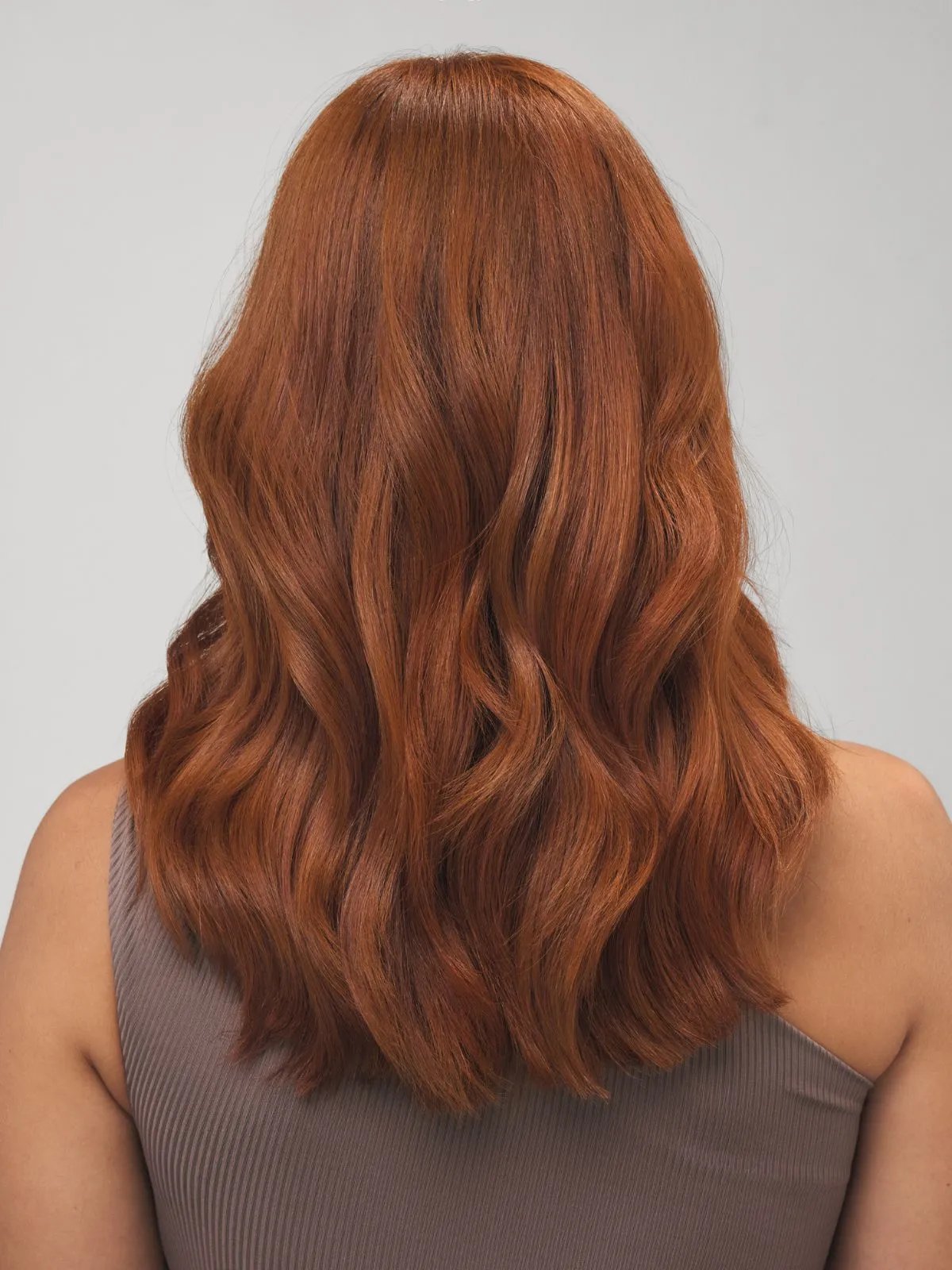 Model with copper hair styled in tousled waves.