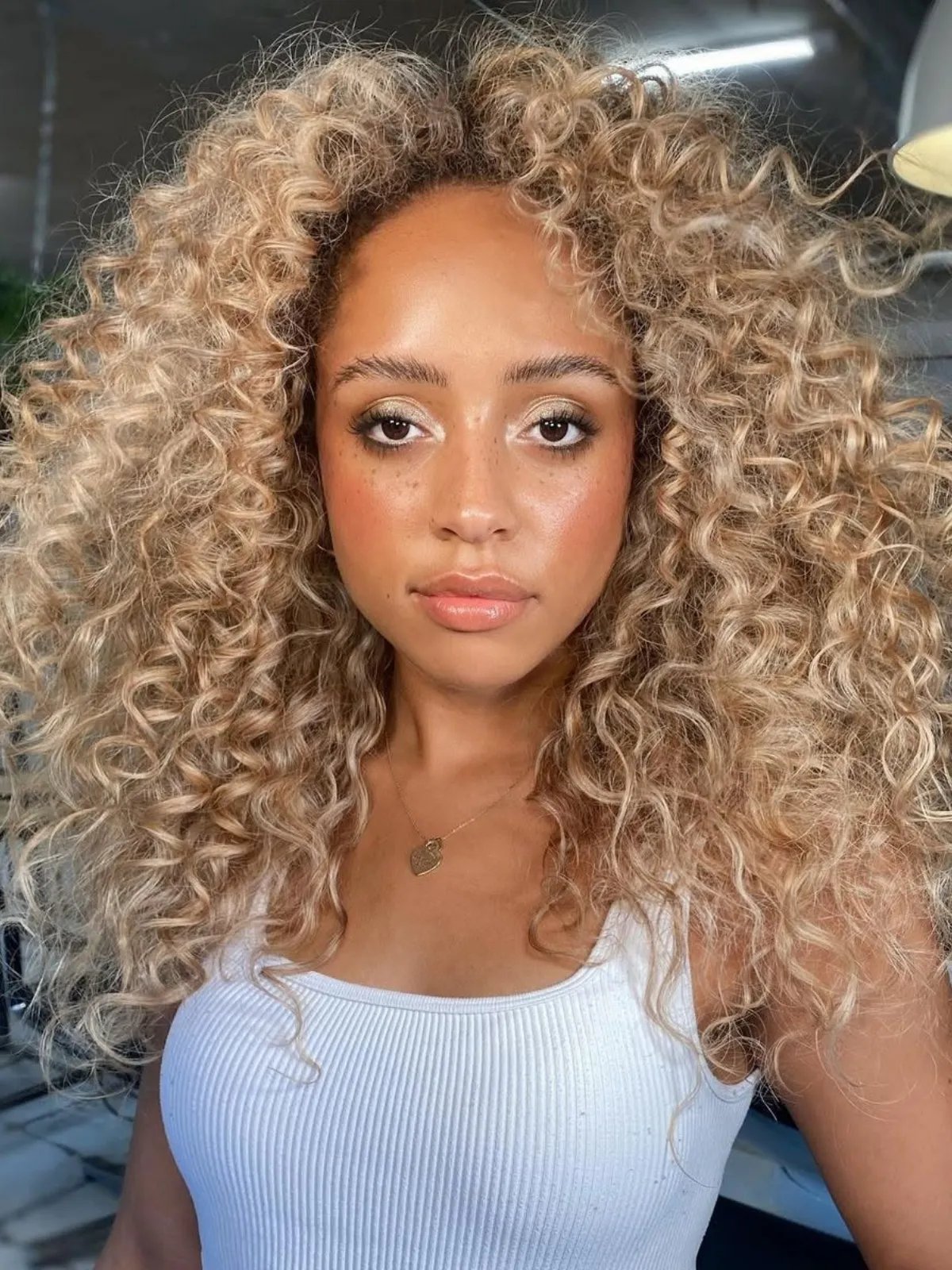 Model with full, glossy, butter blonde curls.
