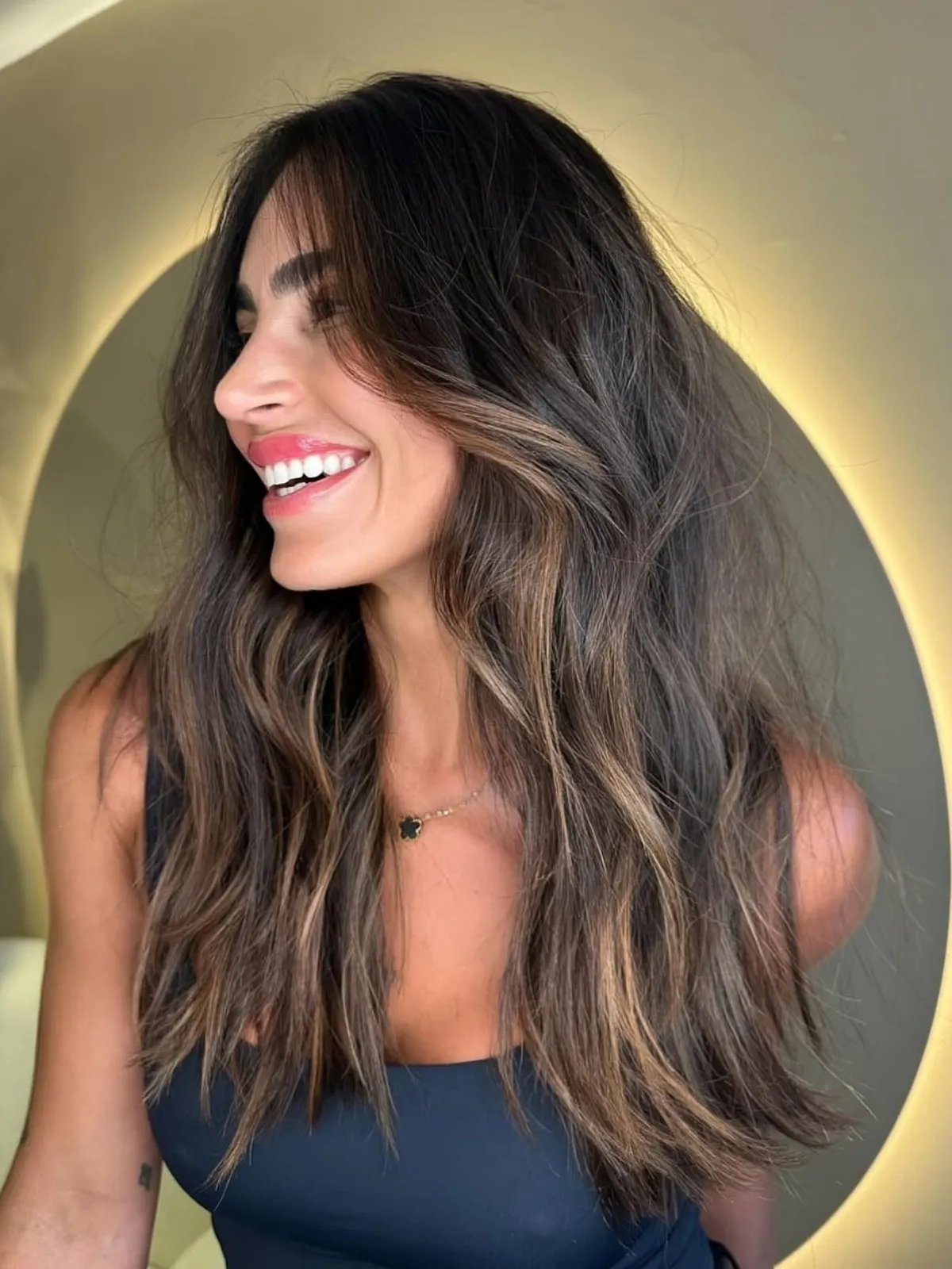 Subtle caramel highlights woven through dark brown hair for a soft, natural glow.