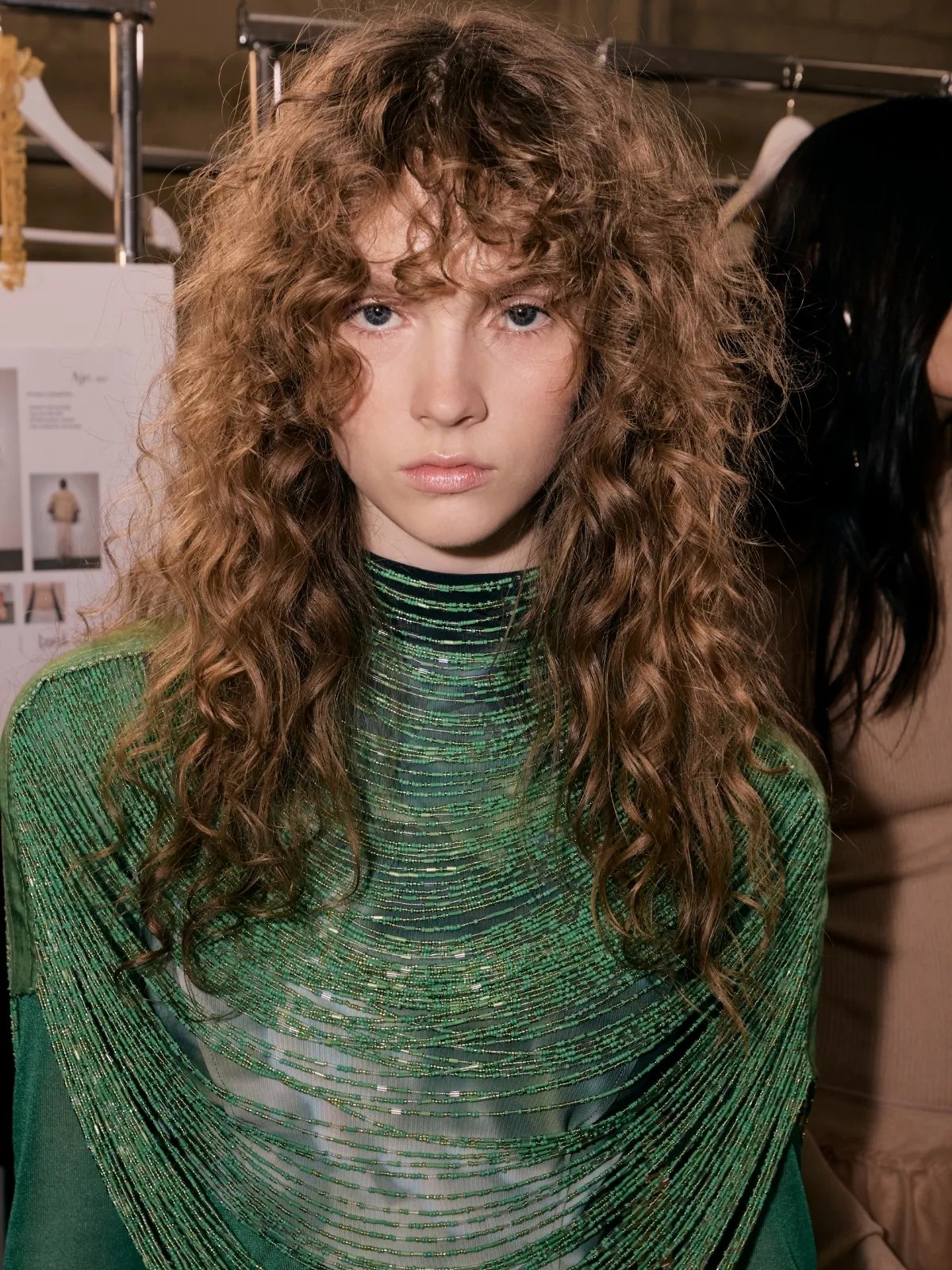 Model with long, light brown, tousled curls.