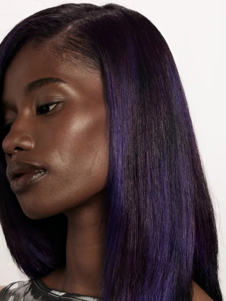 Close-up of model’s dark brown hair and violet highlights.
