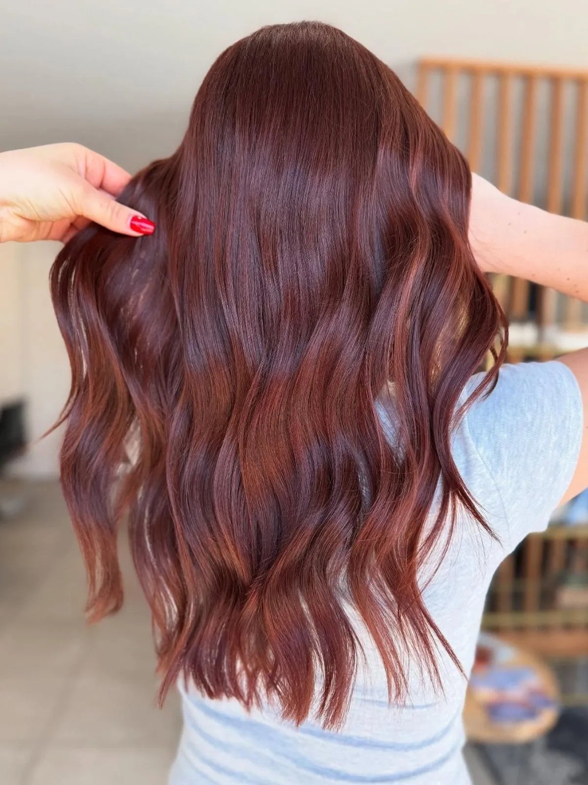 Model with loosely tousled, crimson auburn hair.