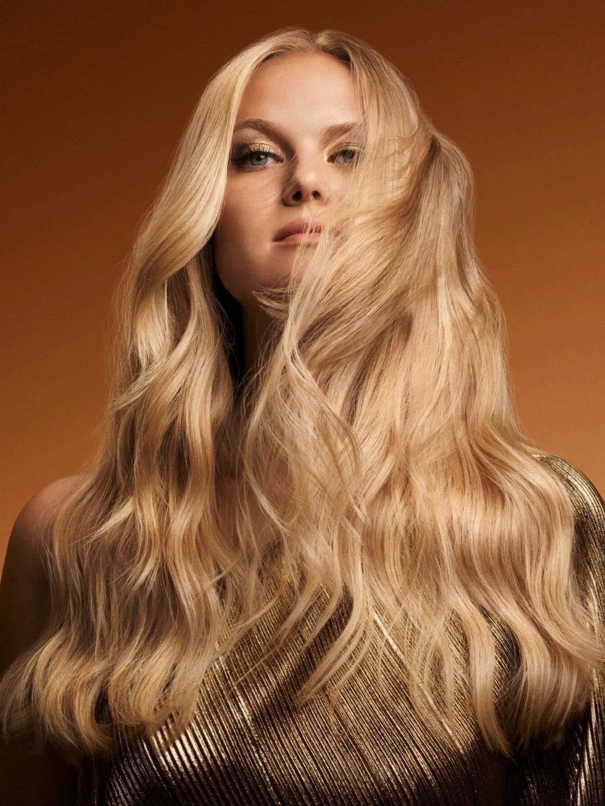 Model with long, wavy, glossy, blonde hair.