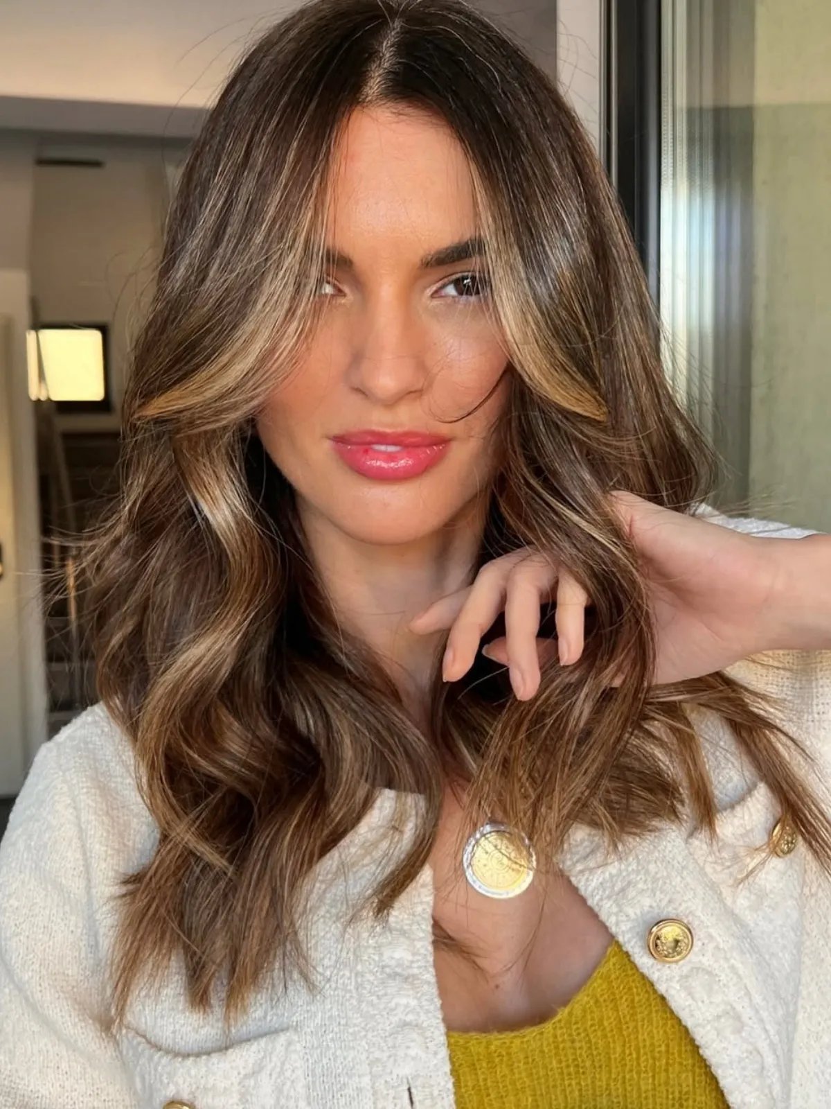 Model with mocha brown-blonde hair featuring blended bronde highlights for a sun-kissed, luminous finish.