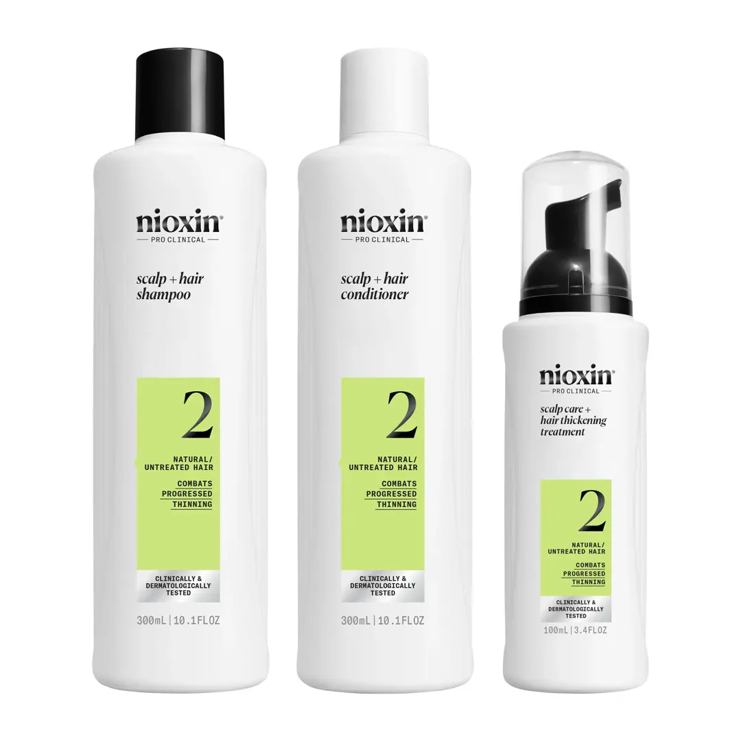 Bottiglie laterali di Conditioner, Shampoo e Hair Thickening Treatment del Kit Sistema 2 di Nioxin su uno sfondo bianco