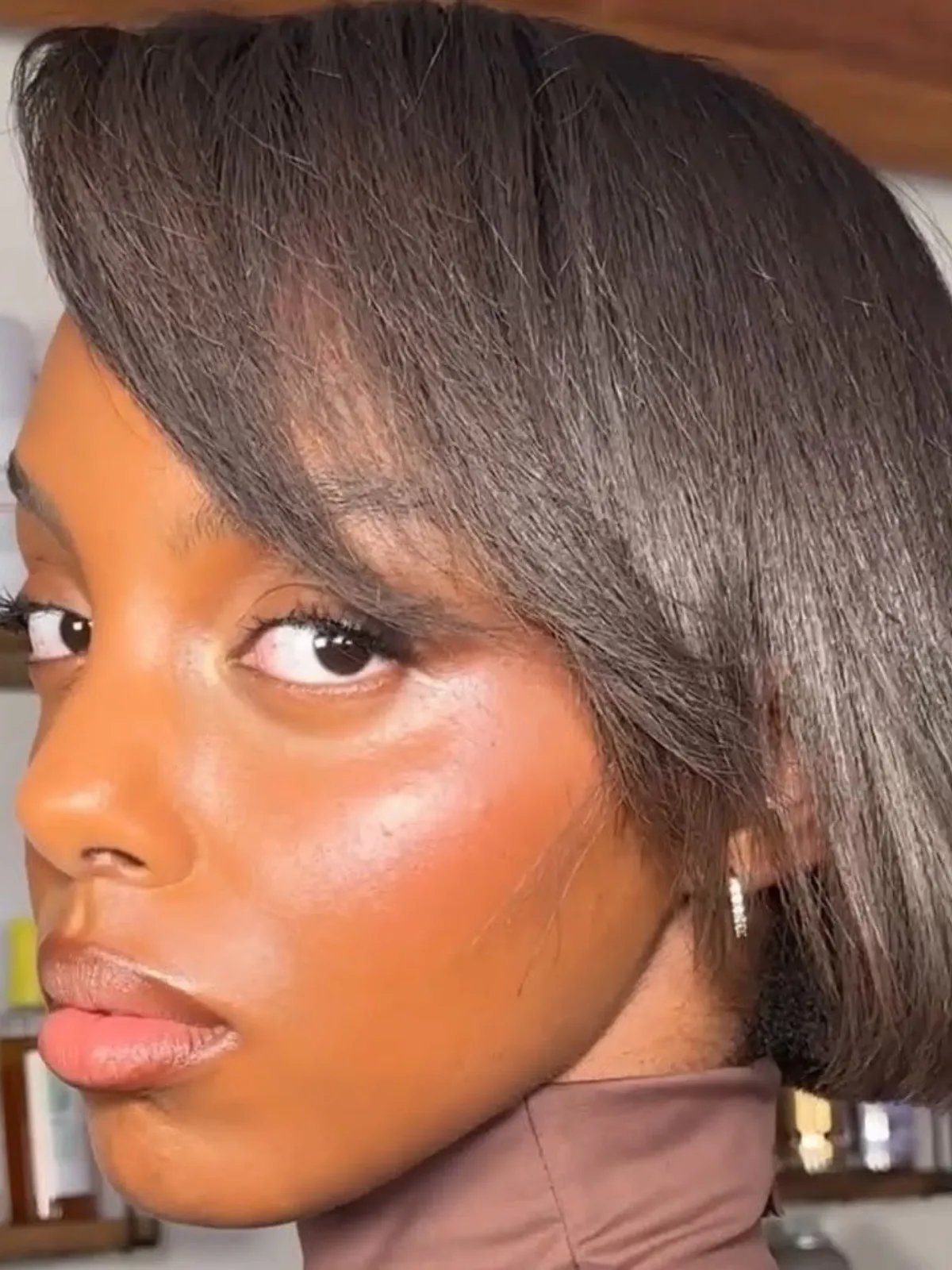 Model with dark brown, relaxed hair styled in a bob.
