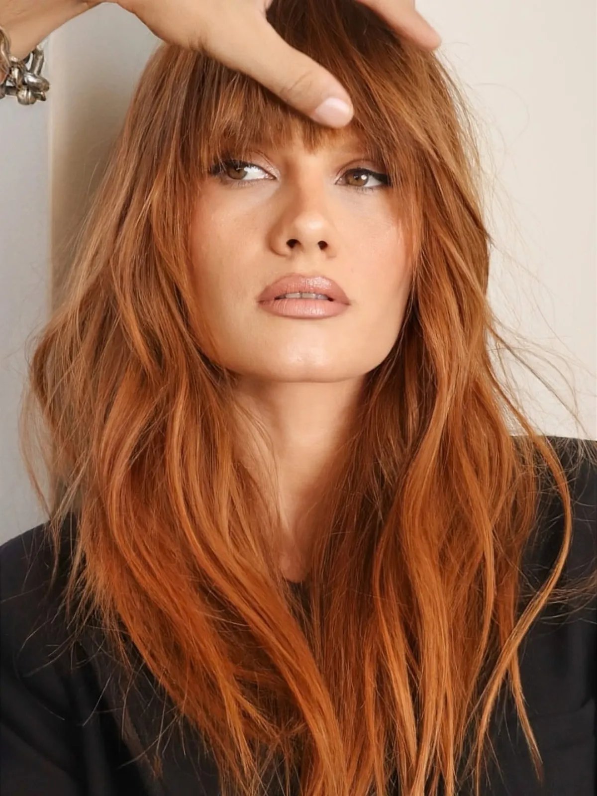 Model with long, ginger hair featuring bangs.