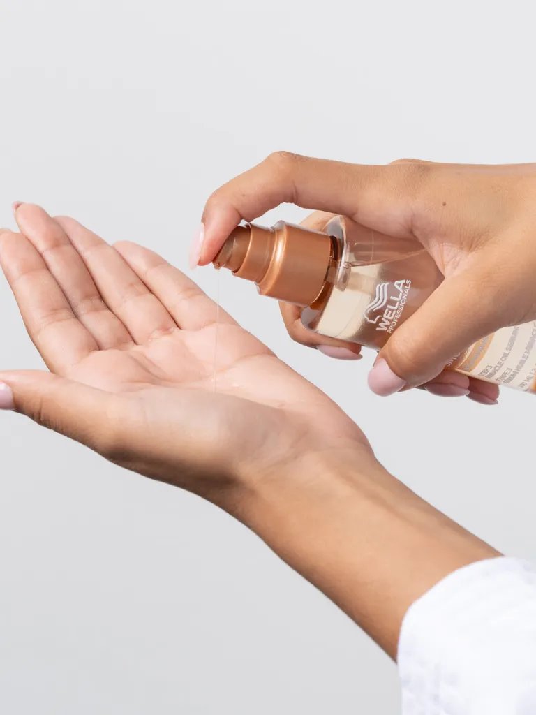 Model pumps ULTIMATE SMOOTH Miracle Oil Serum into palm of hand.