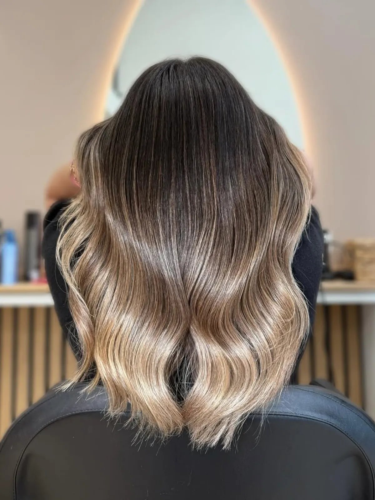 Model with dark brown hair featuring an ash blonde ombre through lengths and ends.