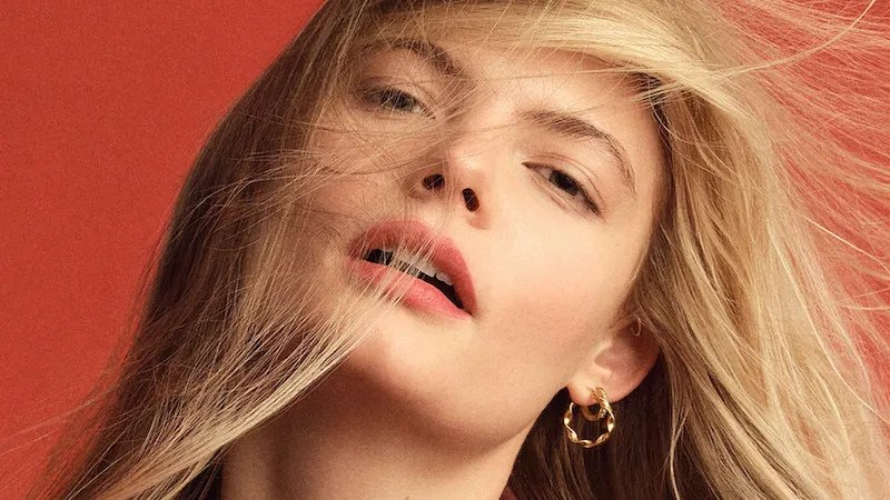 Model with long, blonde hair blowing in wind.