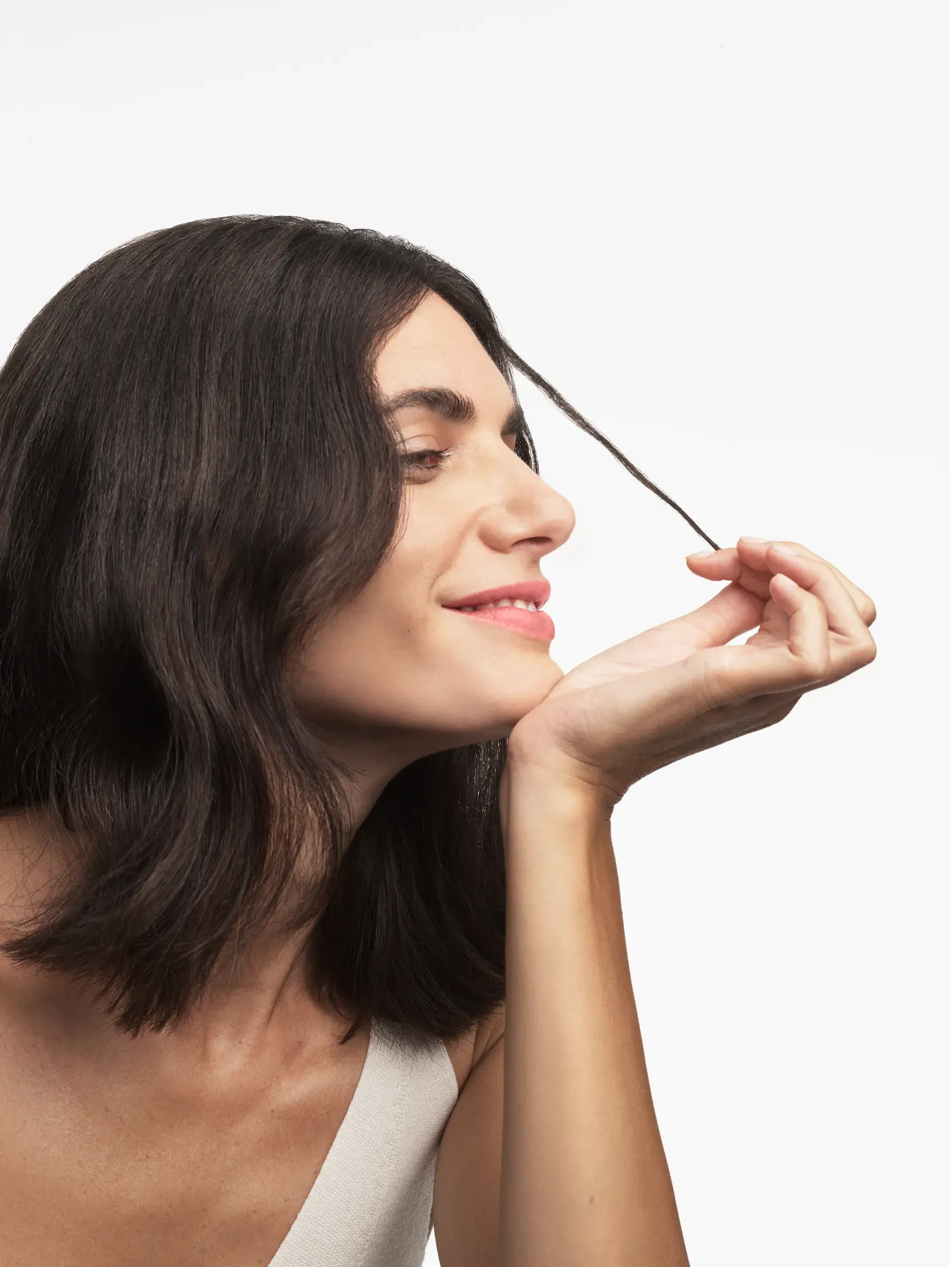 side profile of white brunette woman with short hair stretching some of her hair