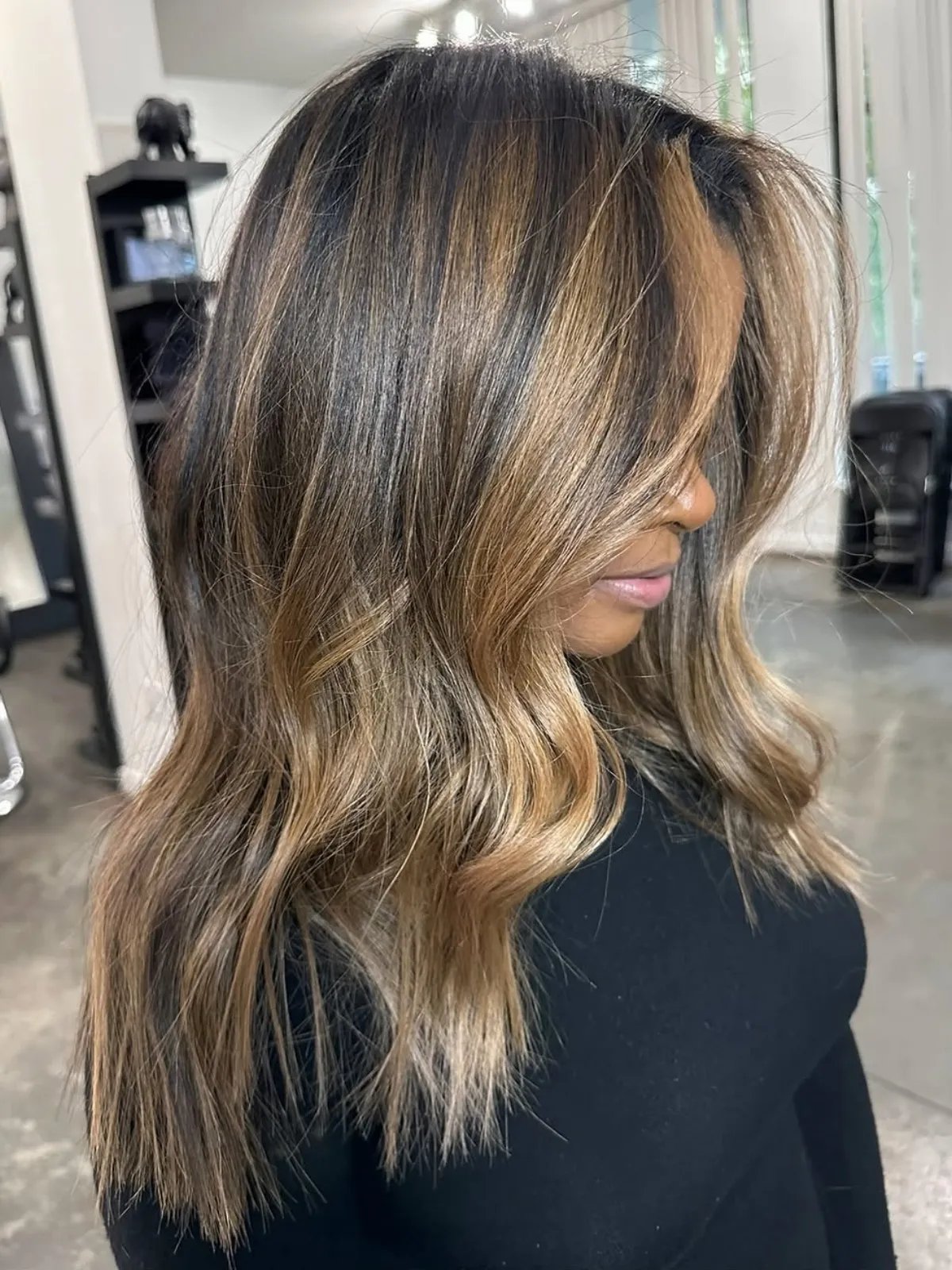 Warm caramel balayage on long dark hair.