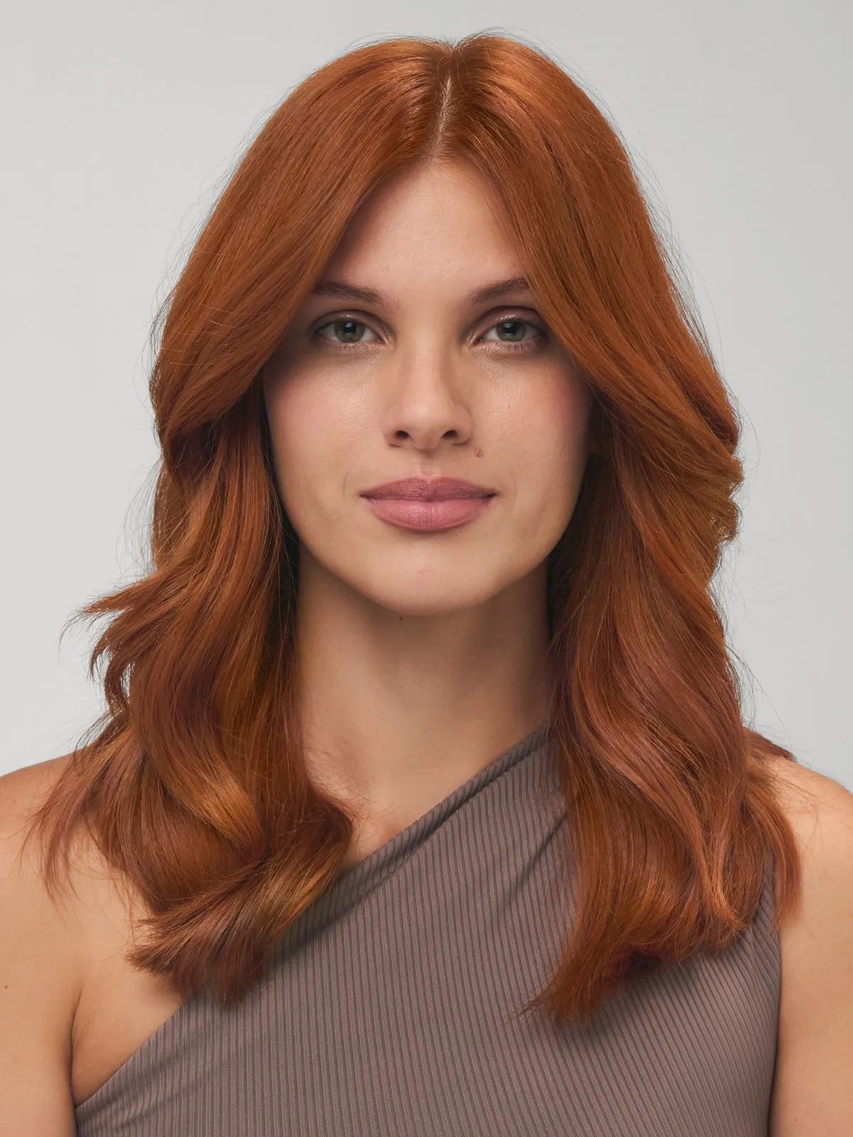 Model with copper hair styled in tousled waves.
