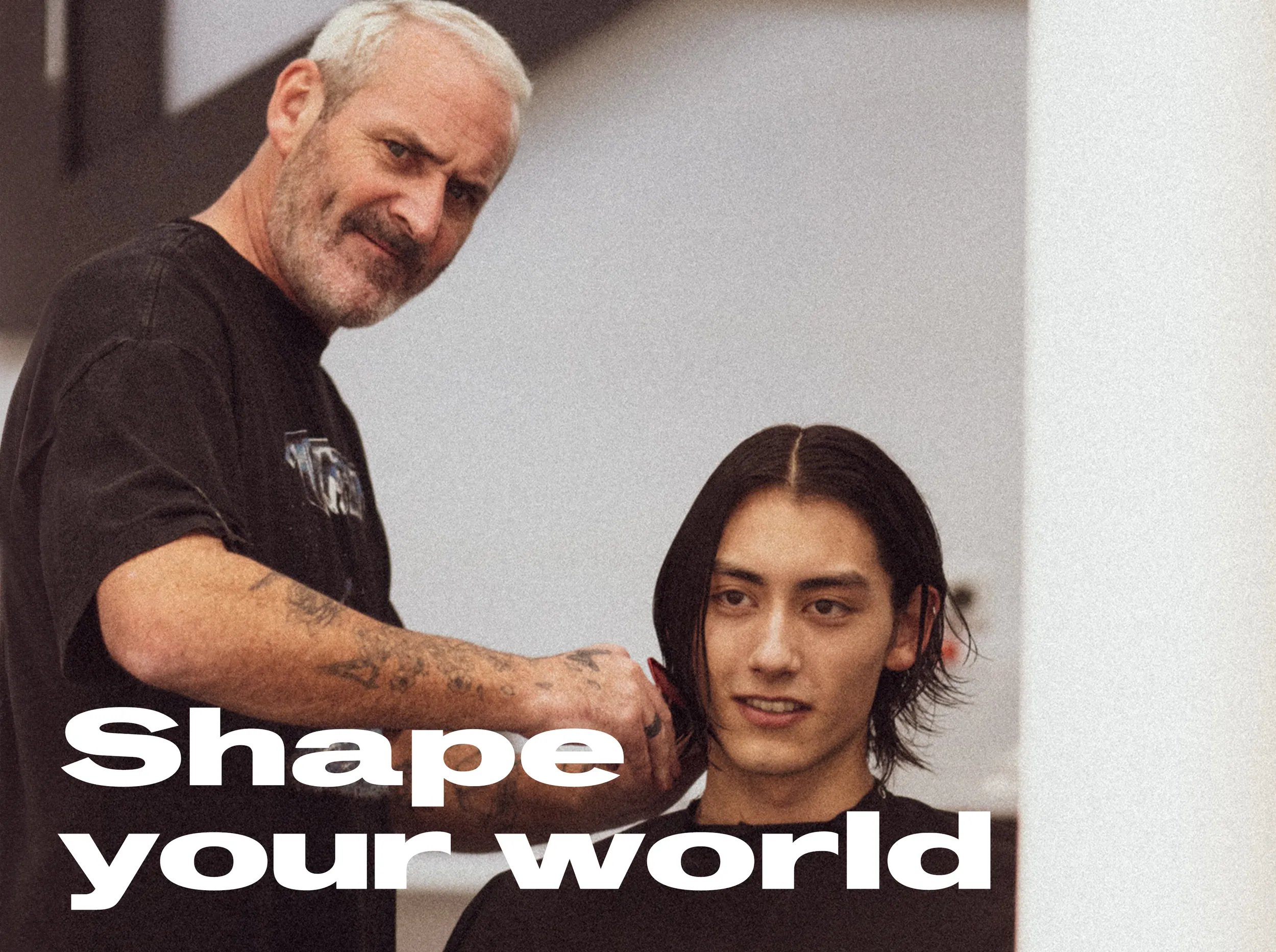 Immagine di una modella e di un parrucchiere che si guardano allo specchio mentre il parrucchiere le taglia i capelli. Il testo in sovrimpressione recita "Dai forma al tuo mondo"