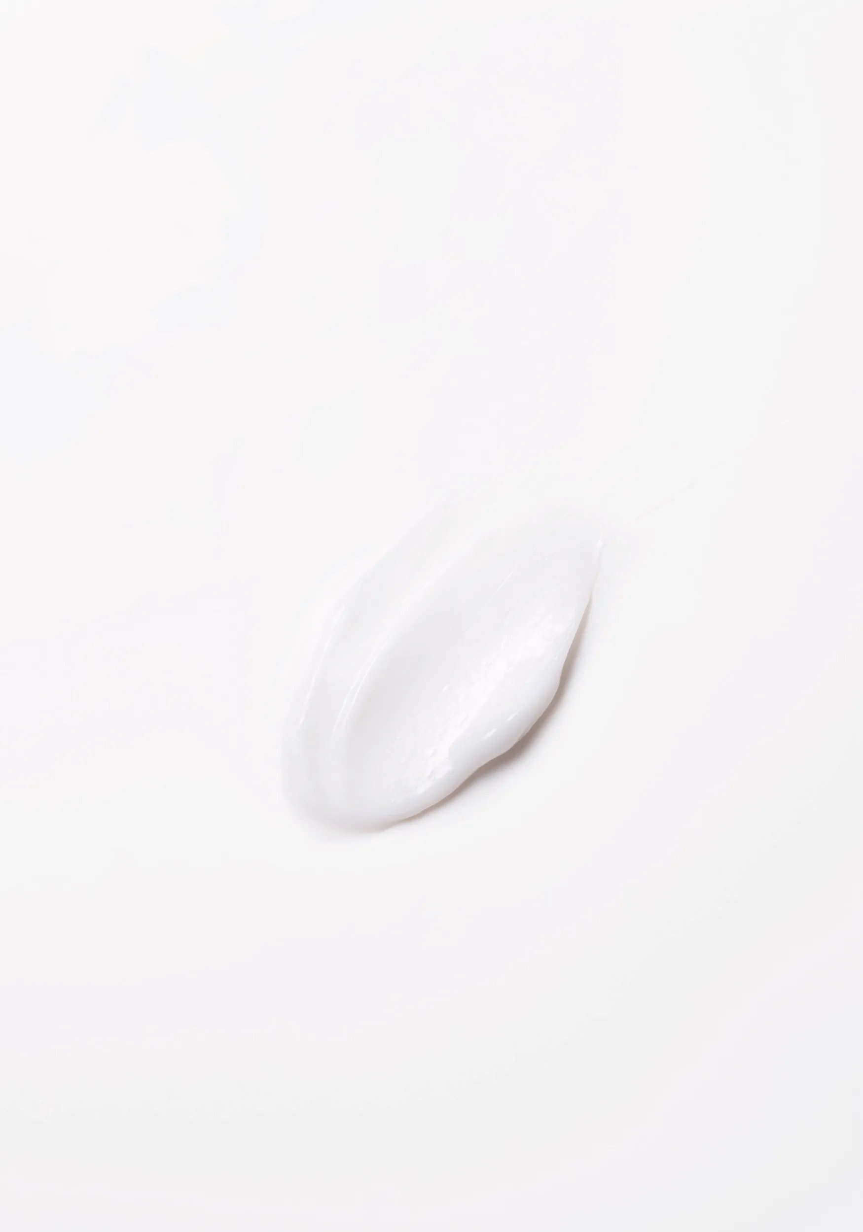Close-up photograph of a circular blob of Invigo Brilliance product on a white background, with text saying 'antioxidant shield, helps control the oxidation process after coloring' and 'metal purifier, protects from harmful metals in water'.