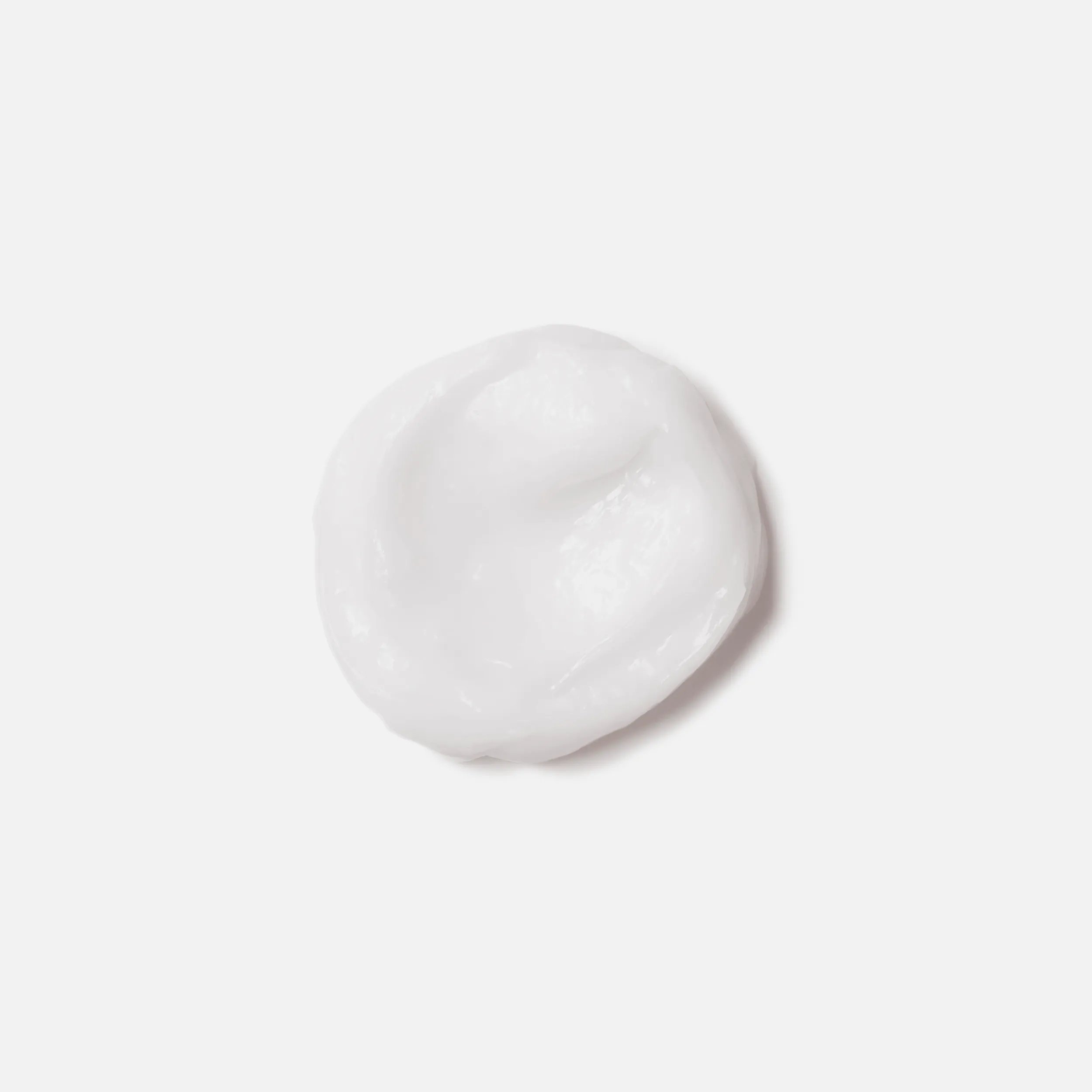 A small dollop of white cream against a plain white background.