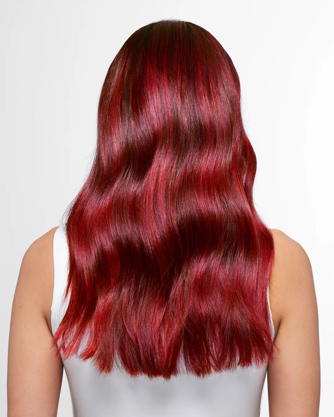 Model faces away from the camera. They have long, vibrant red hair.